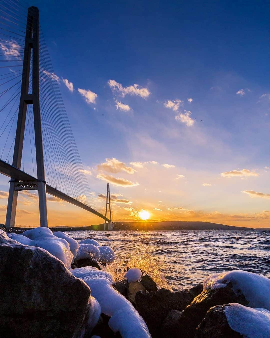 のインスタグラム：「. It's hard to believe that city of Vladivostok, with all its European character, can be reached in just a two and a half hour flight from Tokyo! #NewJourneyJanuary  東京から2時間半で行けるヨーロッパ・ウラジオストク✈︎ ルースキー島連絡橋と一緒に見る夕日は絶景です🌅 . . Photo by @motoristt Post your memories with #FlyJAL  #JapanAirlines #russia #vladivostok #sunset_madness」