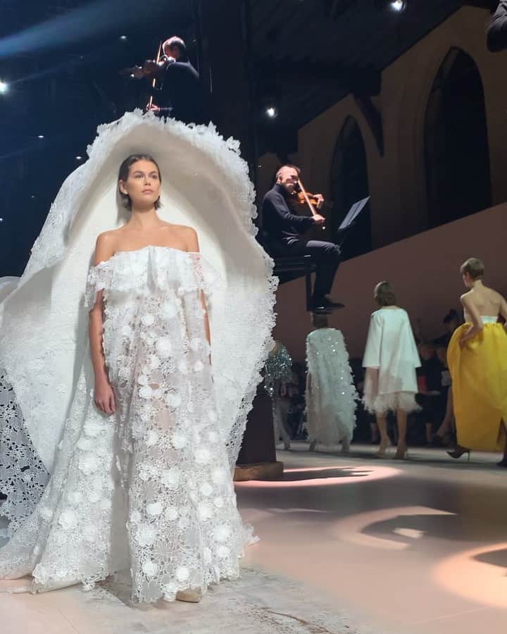のインスタグラム：「クチュール取材：「ジバンシィ（GIVENCHY）」はぜひ動画で見てください。大きな帽子が揺れる様子やシルクタフタをたっぷり使ったドレスの丸いふくらみが、背中を飾る大きなリボン。着るか着ないか、着れるか着れないかなど関係なく、ただ“あ～きれいだな”と眺めていただきたい。バイオリンの生演奏も見どころです。﻿ ﻿ コレクションの全ルックは @wwd_jp のプロフィールのリンクから﻿ ﻿ #ジバンシィ #GIVENCHY #givenchycouture #coutureweek #hautecouture #pariscoutureweek #kaiagerber #カイアガーバー」