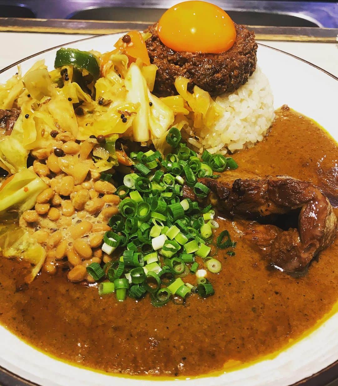 桜井誠のインスタグラム：「今日のスパイス活動は、お初の吉田カレー 天気が悪かったので、並びも少ないだろうと予想して仕事帰りに向かってみれば、一名待ちのみで大正解！ キーマ辛口小　豚、中華アチャール、納豆トッピングをオーダー  バナナの香りが印象的なカレーで、塩分控えめの優しい味。豚はめっちゃ大きくってトロトロ！すげー美味い！ 中華アチャールのホールスパイスが心地よいアクセントになっていて、混ぜながら食べると食感の変化が楽しい！納豆も相性抜群！ 自分好みにマゼマゼしながら大満足で完食！ これは虜になる人が続出するわけですな。 俺も気づいたらまた並んでる気がするw ごちそうさまでした！ #カレー　#吉田カレー　#スパイストラベラー　#curry」