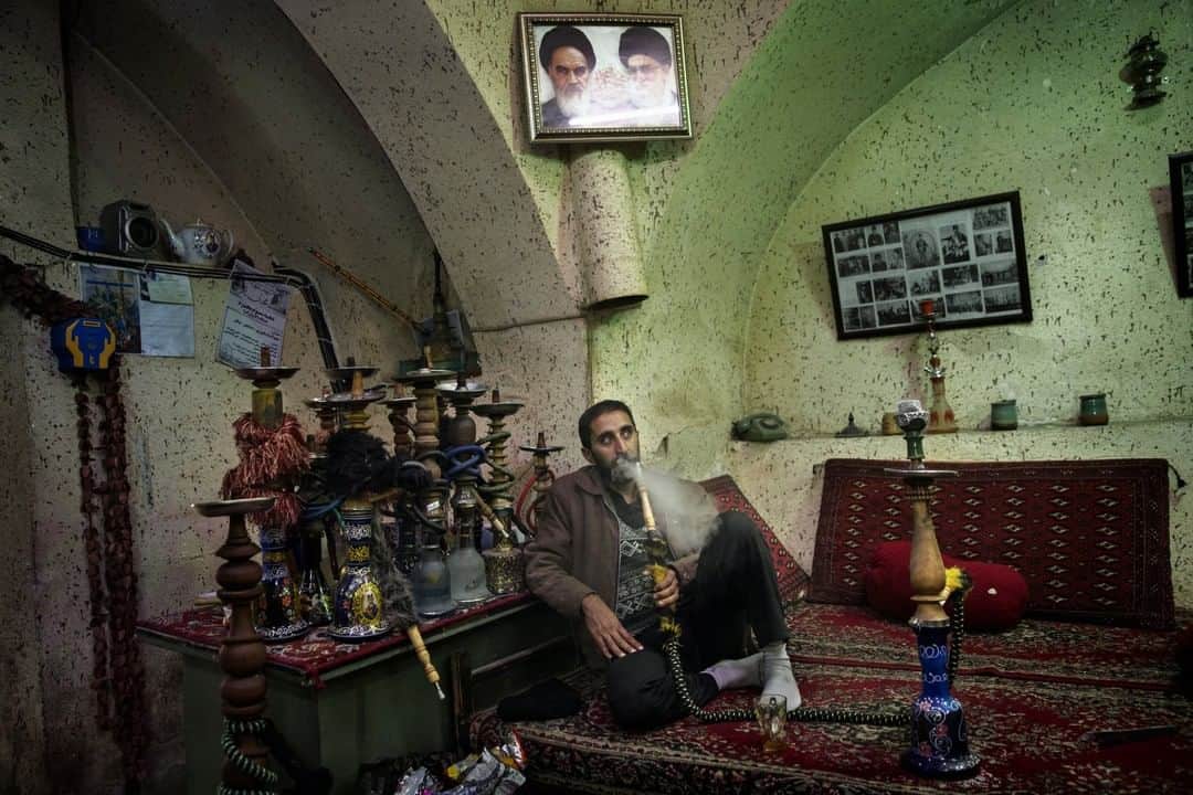 ナショナルジオグラフィックさんのインスタグラム写真 - (ナショナルジオグラフィックInstagram)「Photo by @adamjdean | A man smokes a "shisha" pipe under a poster of Ayatollah Khomeini in Qom, Iran, December 2013.」1月29日 12時35分 - natgeo