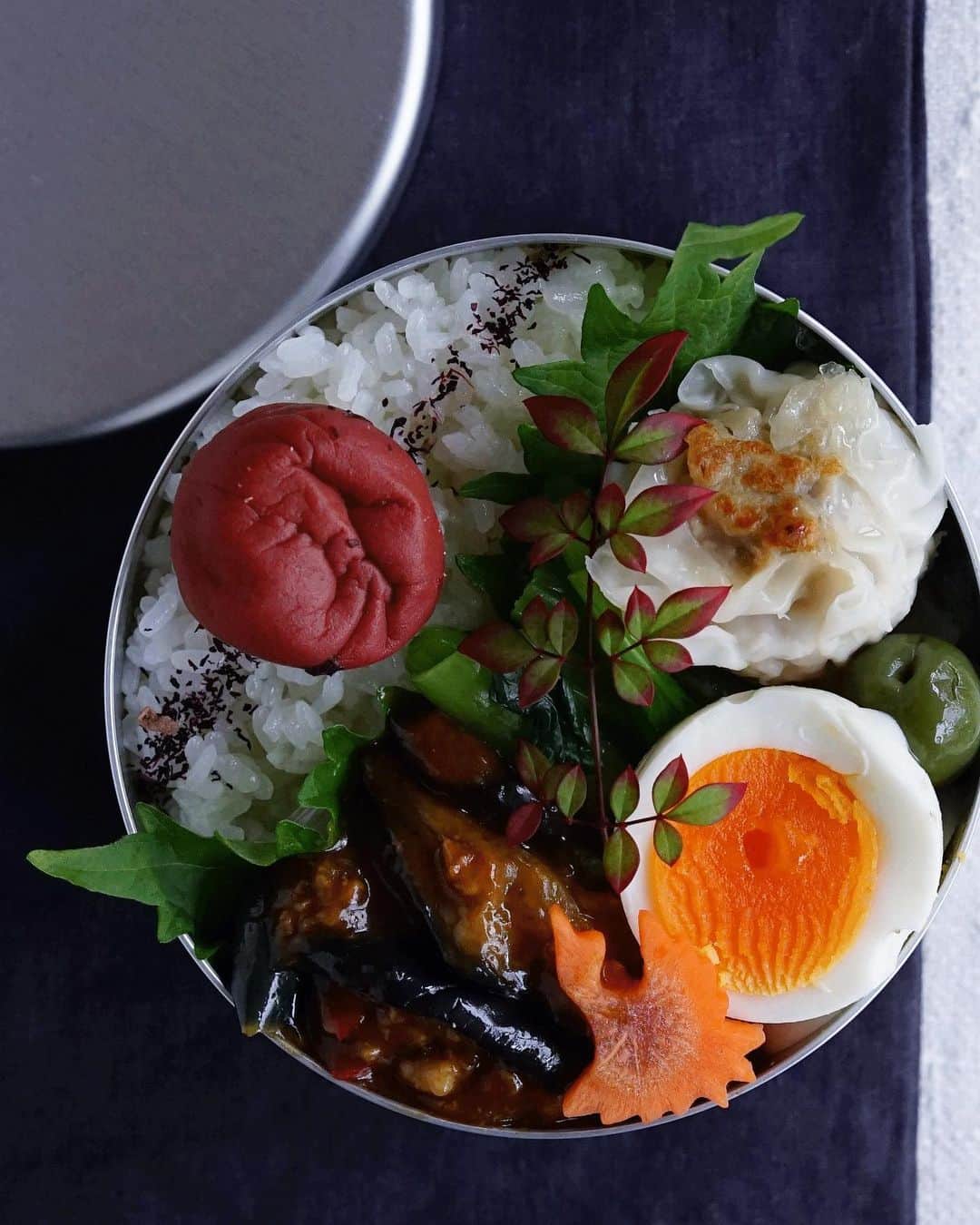 Ryoko Yunokiのインスタグラム：「+ + + Spicy eggplant and minced meat stir-fry bento/麻婆茄子弁当 . *rice and umeboshi *grilled shumai dumpling *spicy eggplant and minced meat stir-fry *hard-boiled egg *green olive *blanched komatsuna leaves salad with mustard dressing . ＊ご飯と梅干し ＊麻婆茄子 ＊焼き焼売 ＊ゆで卵 ＊オリーブ ＊小松菜の辛し和え + + + #bento #お弁当 #丸の内弁当 #f52grams #アルミ弁当」