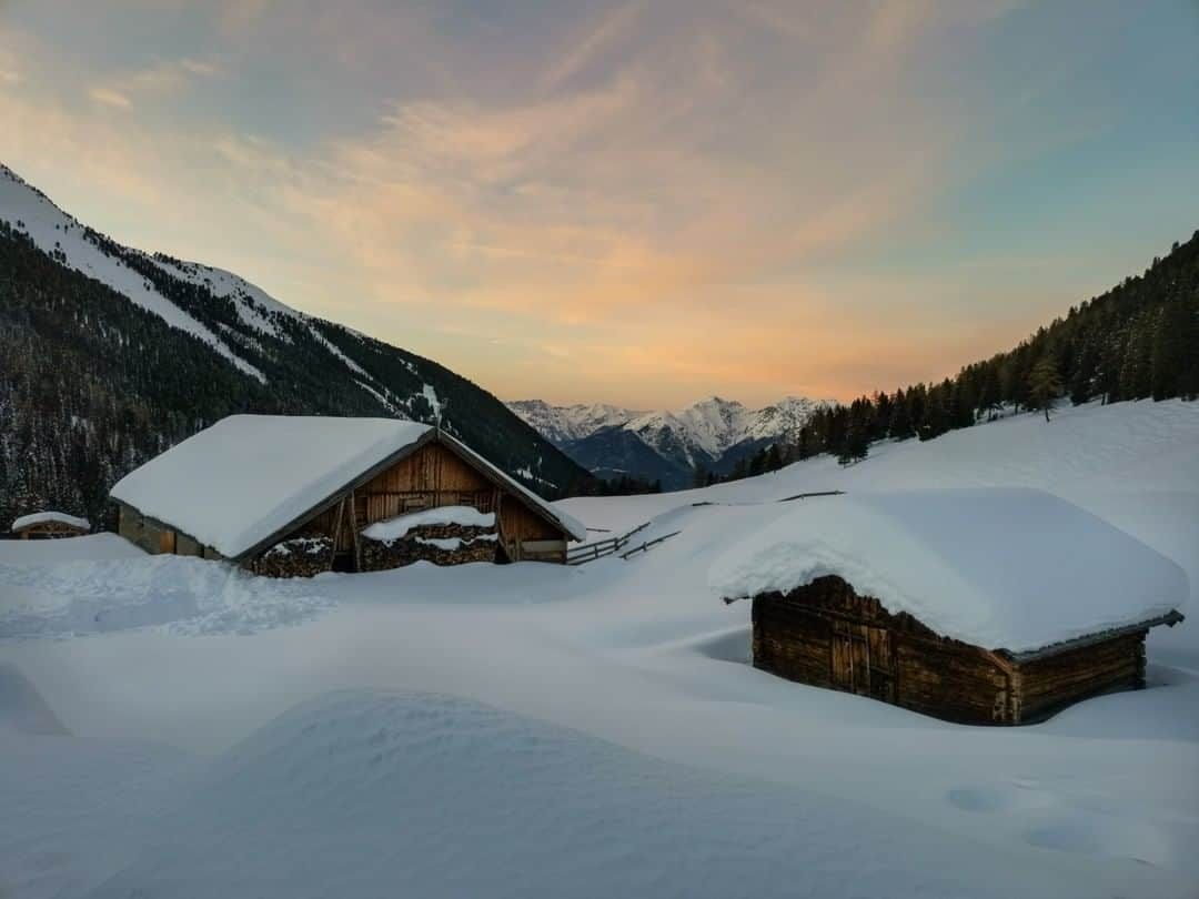 National Geographic Travelさんのインスタグラム写真 - (National Geographic TravelInstagram)「Photo by Robbie Shone @shonephoto | The sun sets over two sleepy wooden barns, close to Kemater Alm in Tirol, Austria. Blanketed in a thick layer of deep snow, these winter months turn the Austrian Alps into a winter wonderland.」1月9日 22時08分 - natgeotravel