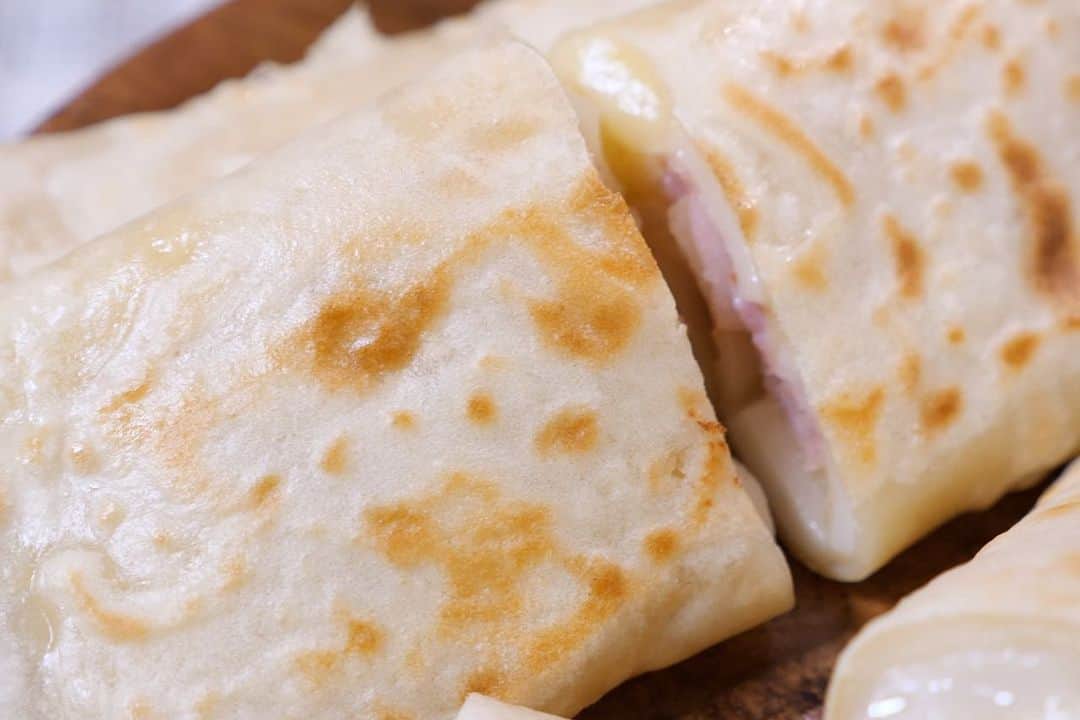 かっちゃんねるさんのインスタグラム写真 - (かっちゃんねるInstagram)「残ったお餅とフライパンで簡単🌯！﻿ ﻿ 「セブン○レブン風　ベーコンもちチーズブリトー」﻿ ﻿ 【ブリトー生地（３枚分）】﻿ ・薄力粉 100g・ベーキングパウダー 2g・砂糖 5g・塩 2g・水 160ml﻿ ﻿ ・切り餅（16等分） 2個・ベーコン（薄切り）6枚・ミックスチーズ 90gほど・サラダ油、塩こしょう、マヨネーズ 適量﻿ ﻿ ﻿ ◎生地材料の粉類を混ぜ、水を少しづつ加え混ぜる→フライパンでベーコンを焼き一旦取り出す→フライパンに薄くサラダ油をぬり1/3を流し入れ中火で焼く→表面が固まってきたら裏返して切り餅の1/3とミックス1/3をのせる→蓋をして弱めの中火で３分ほど焼く→塩こしょうとマヨネーズをかけ焼いたベーコンを2枚のせて巻く。﻿ ﻿ ﻿ あのコンビニの人気商品のようなもちもちの生地と、とろとろなお餅とチーズが美味しいレシピです﻿ 😋🌯🎉﻿ ﻿ #餅 #お餅 #鏡開き #お餅アレンジ #ブリトー #トルティーヤ #料理 #レシピ #料理動画 #簡単レシピ」1月10日 12時21分 - kattyan1011