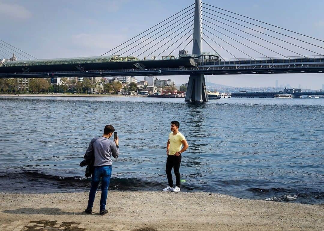 National Geographic Travelさんのインスタグラム写真 - (National Geographic TravelInstagram)「Photo by @dina_litovsky | Two friends take photos by the Golden Horn waterway in Istanbul, Turkey, with Ataturk Bridge in the background. For more images, follow me @dina_litovsky.」1月11日 22時08分 - natgeotravel