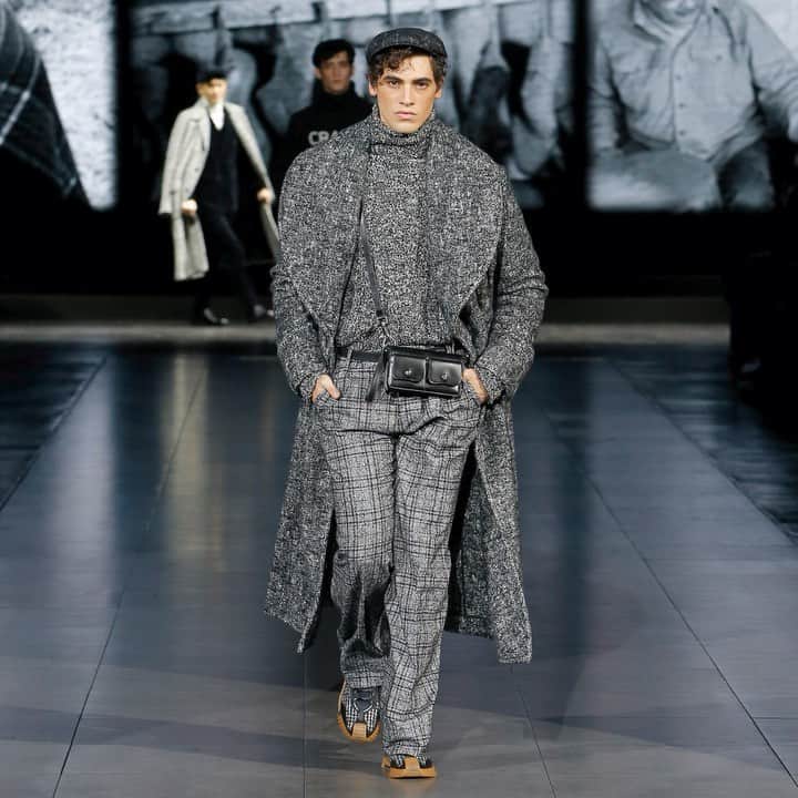 のインスタグラム：「The #DGMestieriDArte Men's Fall Winter 2020/21 Fashion Show. The greystone matching look, composed of a warm knitwear sweater and oversized coat, is paired with a multifunctional black bag that emphasizes the tailoring of the garments.  The background sounds recall those of real craftworks. #DGArtisticCraftsmanship #DGMenFW21 #DolceGabbana #DGFattoAMano」