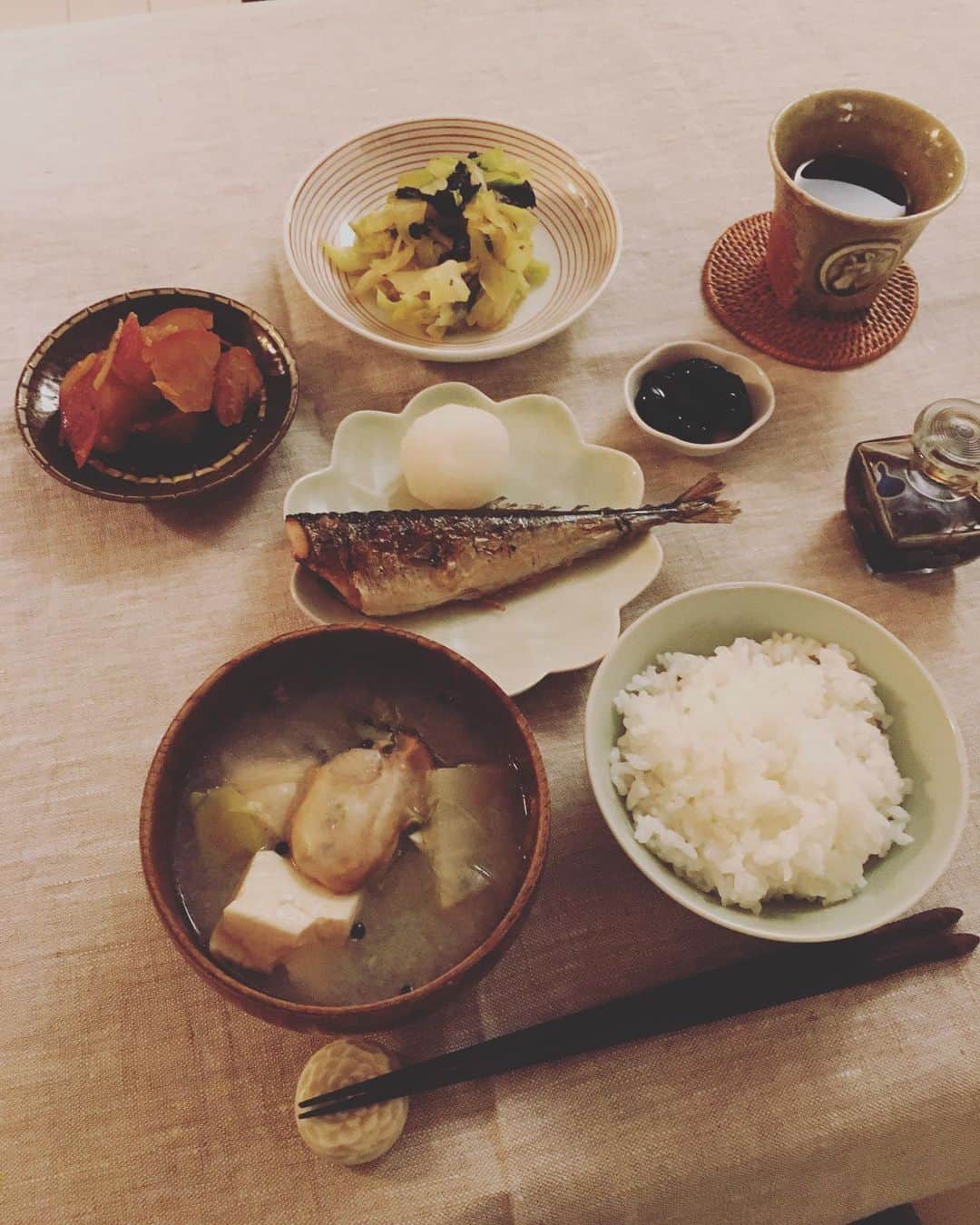 のインスタグラム：「疲れがたまる日曜の夜。しっかりごはんを食べてリセット。  お鍋の残りスープに牡蠣を入れて、牡蠣スープへリアレンジ。リッツボンの伊藤さんに頂いた徳島のさつまいもは白ワインと柚子皮でさっぱり煮。大好きな、きゃべつの海苔黒酢和え、さんまの塩焼き、黒豆煮。  お芋とお豆の煮たのがとにかく好きで、常備菜にどちらかはあることが多い。  #猫沢飯」