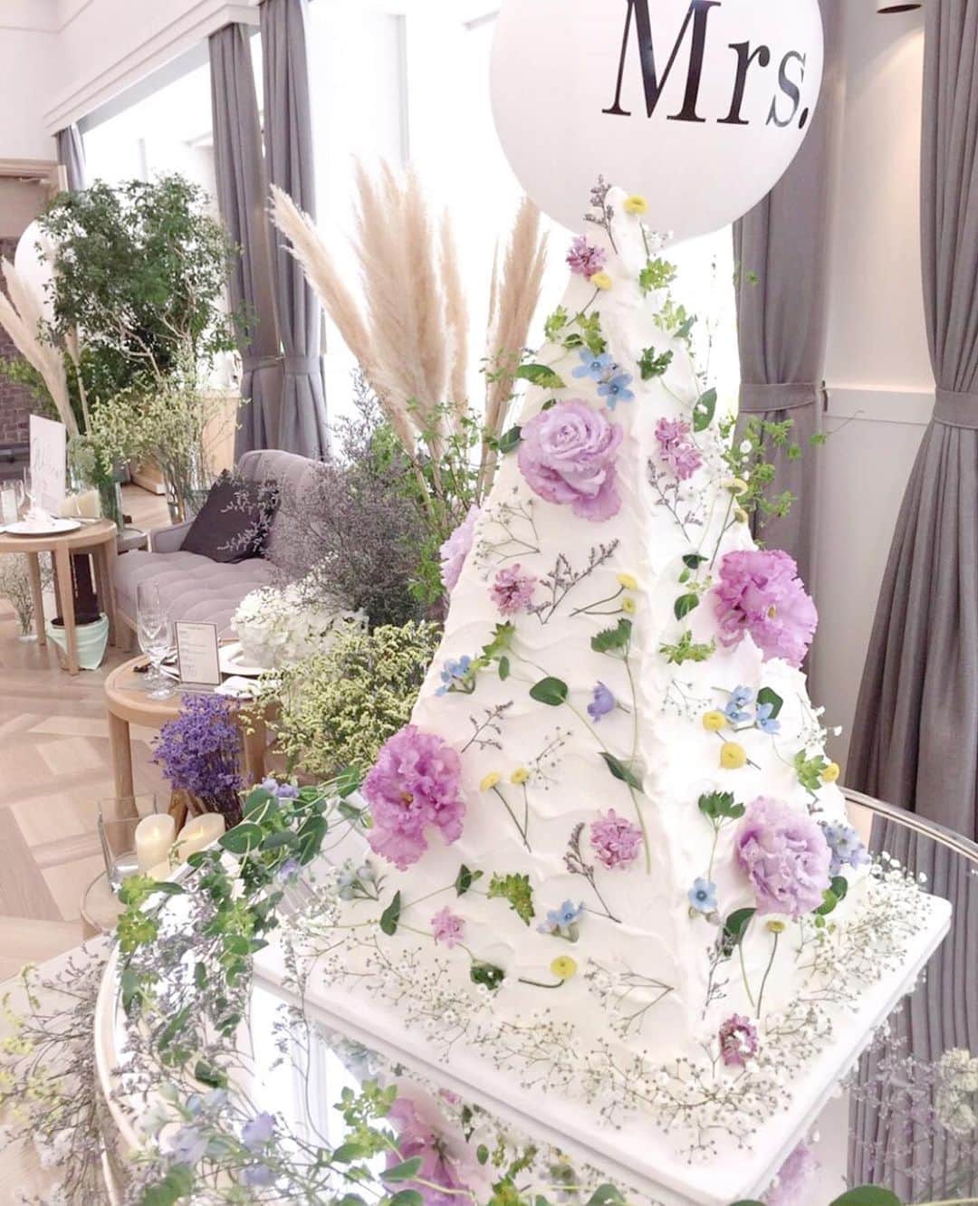 のインスタグラム：「華やかで可愛い♡ウェディングケーキ5選🍰💗 . @weddingnews_editor まいにち150記事を配信♩アプリもよろしくね💕 . . 📷本日のカバーPhoto🕊♩+ﾟ* . @oo00.nami.00oo さん . 華やかでどれも可愛い😍oo00.nami.00ooさんのつくる #ウェディングケーキ 🍰💗 . カバーは三角のタワー型ケーキです🌿💕 . パープルのお花をメインに、小花がたっぷりでとてもおしゃれですよね💜 . ほかの #ウエディングケーキ も素敵なのでぜひスワイプ👉🏻してみてくださいね✨♩ . . ...................................... ❤️【WeddingNews情報】❤️ . 本日新着のオススメ記事をご紹介します✨ . . ①IKEAで見つけた♡今すぐ買いたいウェディングアイテム12選💕《テーマ・装飾》 . . ②プロフィールムービーを自作！簡単で使える優秀アプリを紹介💕《DIY》 . . ③花嫁の手紙、なしでもOK？代わりになる演出も紹介！💕《演出》 . . ④連名は？手渡しする場合は？失敗しない招待状の宛名書きのポイント♩💕《お金・段取り》 . . ⑤これでおしゃれ花嫁の仲間入り♡おすすめの外注ヘアメイクさん10選💕《ビューティー》 . . ※《》は記事のあるカテゴリー名❤️ . などなど、その他にも新着記事が配信中💕アプリダウンロードがまだお済みでない方は是非 @weddingnews_editor のURLからダウンロードしてみてくださいね💕 . . . ＼📷投稿お待ちしています／ . 花嫁はもちろん、業者さんも大歓迎✨ アナタのお写真をご紹介してもOKという方は、ぜひ #ウェディングニュース にお写真を投稿してください💕 . . ⬇︎関連アカウント⬇︎ . 🕊メインアカウント 【 @weddingnews_editor 】 . 💒インスタグラムで式場探し 【 @weddingnews_concierge 】 . 👰花嫁から式場探し 【 @weddingnews_brides 】 . . その他、編集部からの連絡専用 @weddingnews_contact や、スタッフ個人の連絡用として @WN_xxxx（xxxは個人名）があります💕 . . …………………………… ❤️ウェディングニュースとは？ …………………………… . 花嫁のリアルな”声”から生まれた、花嫁支持率No1✨スマホアプリです📱💕 . . 🌸知りたい… #結婚式準備 に役立つ記事を毎日150件配信中♩ . 🌸見たい… インスタの #ウェディング 系投稿TOP100が毎日チェックできる＊IG画像の複数ワード検索も可♩ . 🌸叶えたい… 式場をはじめとした  #結婚式 関連の予約サイトが大集合♩ . 🌸伝えたい… 自分の結婚式レポ『マイレポ』が簡単に作れる♩卒花嫁のレポが読める♩ . . @weddingnews_editor のURLからDLしてね✨ . . . #花嫁 #ウエディング #プレ花嫁 #プレ花嫁準備 #2020春婚 #2020夏婚 #ケーキ #スイーツ #2020冬婚 #2020秋婚  #全国のプレ花嫁さんと繋がりたい #プロポーズ #デザート #カフェ #カフェ巡り #スイーツ #パティシエ #ケーキ入刀 #ファーストバイト #ナチュラルウェディング #ガーデンウェディング #装花 #ラプンツェル」