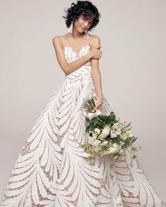 エル・マリアージュのインスタグラム：「2020 WEDDING TREND✍️【ダイナミックレース】今年は上品、エレガントなだけじゃないレースにも注目を。こちらは発表当初から話題を呼んだオスカー・デ・ラ・レンタのデミクチュールライン。印象的なシダ模様は、アトリエの職人が一枚づつ、形や大きさの異なるパーツを刺繍でつないだもの。このドレスを一着仕立てるのに、1440時間もかかるのだそう。まさにクチュール✨✨ .. .. from @ellemariage no.36 Dress ＆Earrings @oscardelarenta @misstreat_  Photo @satoshikuronuma Styling @yuuki.yasuda.n Hair @takayukishibata Makeup @makikoe917 Model @gabrielle.rul  Bouquet @yoshino.m.a .. .. #ellemariage #エルマリアージュ #2020春婚 #2020冬婚 #2020夏婚 #2020秋婚 #日本中のプレ花嫁さんと繋がりたい #ellebride #2020年ウエディングトレンド #fashionbride #oscardelarenta #ミストリート #オスカーデラレンタ #職人技に感動 #続きは最新号＆ウェブで💕」