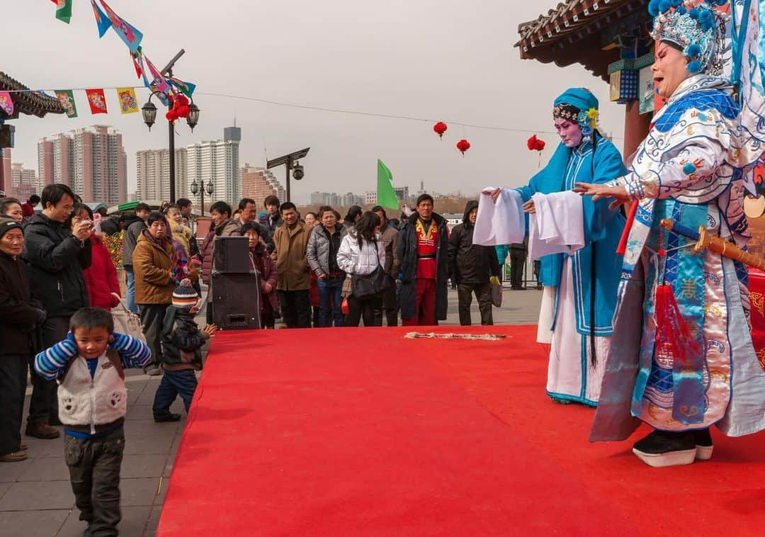 Michael Yamashitaさんのインスタグラム写真 - (Michael YamashitaInstagram)「Not everyone is a fan of the opera, especially this little boy. But during the Chinese New Year celebration, which began on January 25th, opera performances will be taking place in makeshift theaters throughout China. This is the Juxiang Beijing Opera Group performing at Lianhuachi Park in Beijing during a temple fair to celebrate the Spring Festival. Unfortunately this year, due to the coronavirus outbreak, the city has canceled major public events including Lunar New Year temple fairs.  #beijing #beijingopera #springfestival #chinesenewyear」2月1日 6時50分 - yamashitaphoto