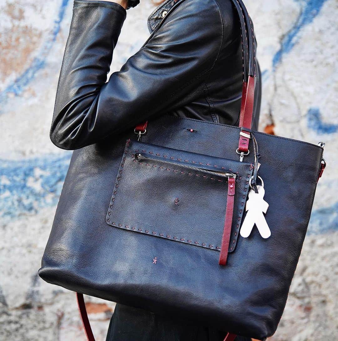 エンリーベグリンのインスタグラム：「Two-in-one!  Amica bag is a large super light tote bag, but it is also a stylish mini crossbody. Perfect for your daily life, ready for your party nights!  #henrybeguelin#fashion#luxury#handmade#bag#amica#twoinone#vegetabletanned#leather#blackcolor#omino#logo#vegetaltannedleather#qualityproducts#」
