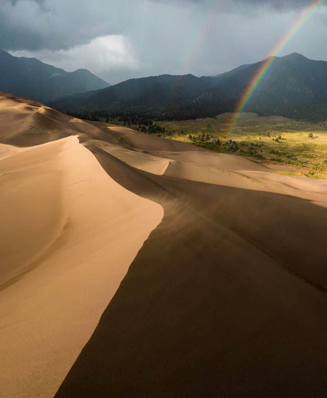 National Geographic Travelさんのインスタグラム写真 - (National Geographic TravelInstagram)「Photo by @chrisburkard | Two completely different landscapes collide, making the Great Sand Dunes National Park and Preserve in Colorado. The mountains and dunes were created by the same forces of wind, with the dunes peaking at up to 750 feet (228 meters), the tallest in North America. After lakes within the valley receded, the exposed sand was blown by the predominant southwest winds toward the Sangre de Cristo Mountains, eventually forming the dune field over an estimated tens of thousands of years. Within the western U.S., the Great Sand Dunes National Park is one of my favorite places to explore.」1月18日 22時13分 - natgeotravel