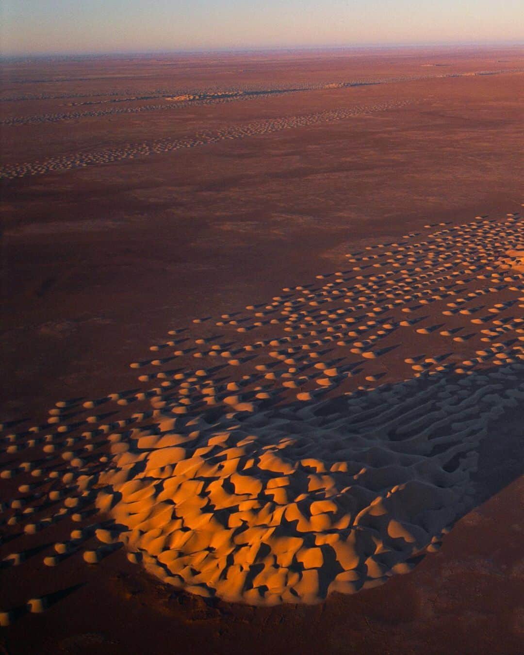 のインスタグラム：「Photo by George Steinmetz @geosteinmetz | Dot-shaped barchan dunes migrate with the wind across the plains of Wadi Hazar, in the Yemeni part of the Rub al Khali (Empty Quarter). Some stuff, like this unusual natural phenomenon, you don’t find in school books: “The universe is not only queerer than we suppose, but queerer than we can suppose.”—J. B. S. Haldane #paramotor To explore more of our Earth from above, follow @geosteinmetz.」