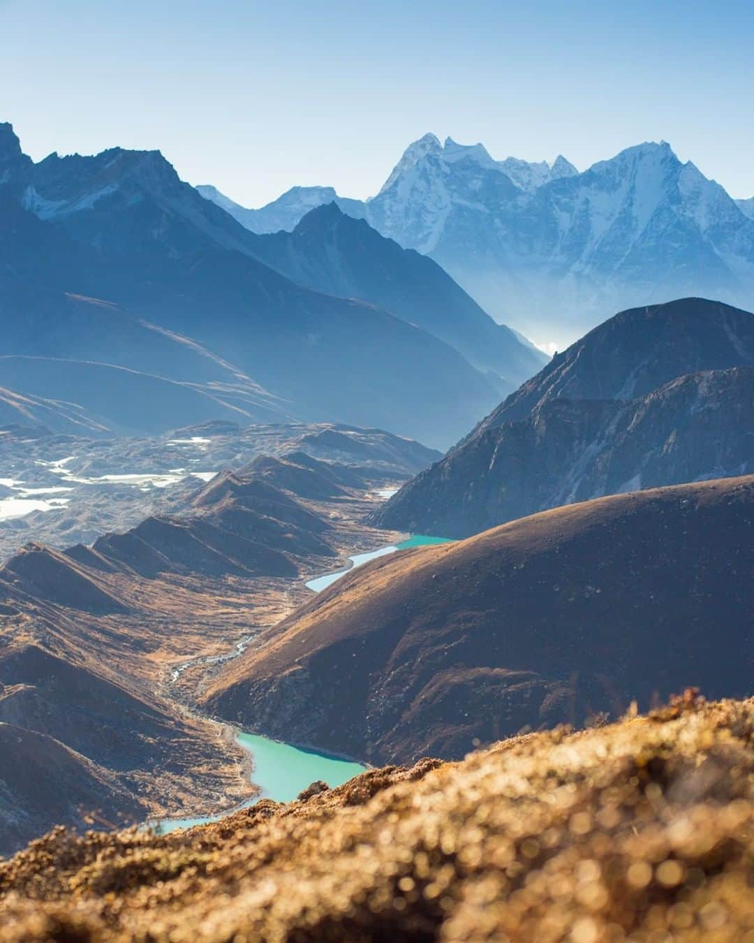 National Geographic Travelさんのインスタグラム写真 - (National Geographic TravelInstagram)「Photo by @emilypolar | Gokyo Valley in the Solukhumbu District of Nepal sits at a breathtaking 4,800 meters (15,700 feet). I lie smugly a few hundred meters above, taking in the view as the morning sunlight thaws out my fingers and toes. Around the bend and out of sight, trekkers slowly scramble up and down the weaving trail leading up Gokyo Ri, a lookout point 500 meters (1,600 feet) above Gokyo, with views of Mount Everest, Lhotse, Makalu, and Cho Oyu.  To see more of Nepal and beyond, follow me @emilypolar. #Nepal #Gokyo #Himalaya」1月22日 10時05分 - natgeotravel