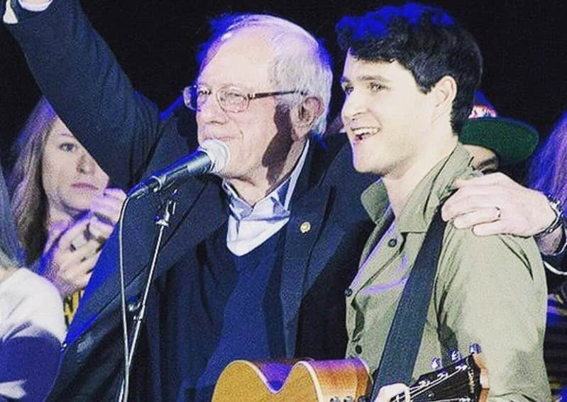 エズラ・クーニグのインスタグラム：「this picture (and caption) are from February 2016 when we played our first-ever Bernie rally in Iowa City. we’re doing it again February 1, 2020 in Cedar Rapids. (Also @boniver is playing a rally the night before in Clive)⁣ ⁣ I still believe that Bernie can win & it’s brutal seeing how much energy goes into convincing voters that one of the most popular politicians in the country (and the one who polls best against Trump) is unelectable. ⁣ ⁣ I don’t feel like I’m separating my values and my pragmatism by supporting Bernie and neither do millions of others ! Anyway, Bernie’s still the landslide favorite among people 35 and under (across racial and gender lines) so talk to your older, skeptical friends and family about why Bernie can actually win. 🌎」