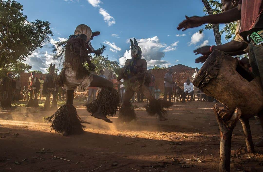 thephotosocietyさんのインスタグラム写真 - (thephotosocietyInstagram)「Photo by @yagazieemezi // The dust rises in Joel, a village in the Eastern Province of Zambia. The chanting and drumming gets louder. Young girls imitate the Nyau with shuffled movements forward, arms and hips swinging energetically side to side. The Nyau make a dramatic lunge and the children quickly retreat, thrilled by the intimidation but mindful to maintain distance. On the opposite side, men keenly watch the fast footwork as if they too, know the steps to follow. The Nyau are not seen as human - masked dancers possessed by the spirits of animals and those long dead which are represented in the carved masks. Having existed for centuries, they can still be found operating predominately within villages, public dances often held after the initiation of young boys into manhood all the while maintaining the mysticism and tradition of their secret society. Follow me @yagazieemezi for more stories and images. @thephotosociety #Zambia #Africanmasquerades #Nyaudancers #everydayeverywhere #everydayafrica」1月25日 0時52分 - thephotosociety