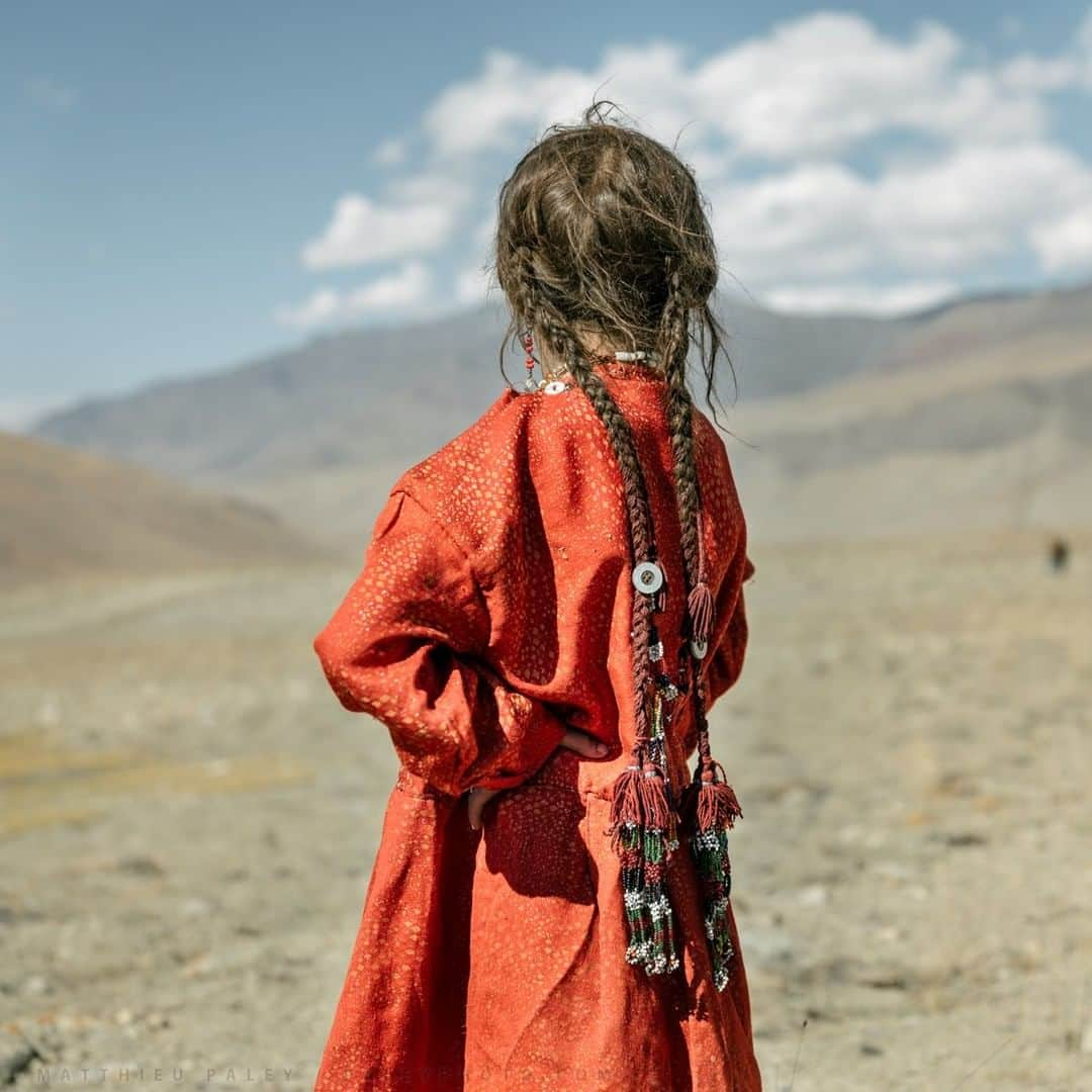 ナショナルジオグラフィックさんのインスタグラム写真 - (ナショナルジオグラフィックInstagram)「Photo by Matthieu Paley @paleyphoto I High up in the Afghan Pamir Mountains, a Wakhi girl waits for her dad to return from herding sheep. Every year during summer, a small community of shepherds moves up to the high pastures with their herd. For up to four months, they live a self-sufficient life with no way of connecting to the outside world. Visit @paleyphoto for more cultural encounters and behind the scenes. #Afghanistan #reddress」1月25日 8時36分 - natgeo