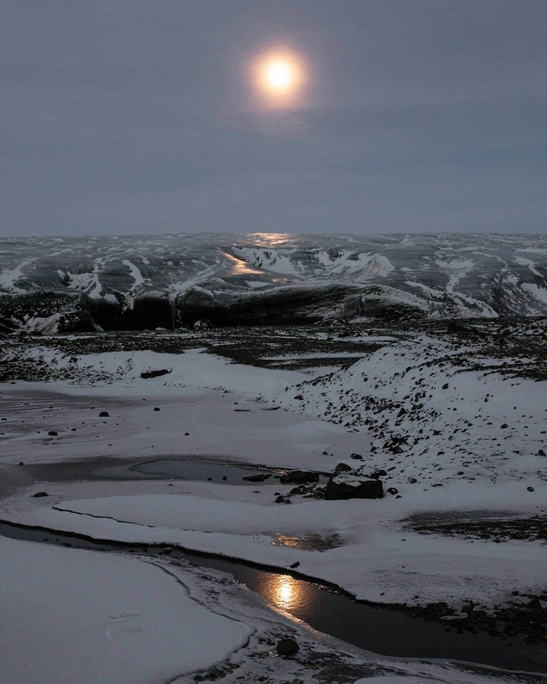 National Geographic Travelさんのインスタグラム写真 - (National Geographic TravelInstagram)「Photo by Matthew Borowick @mborowick | A moonset isn’t exactly something new, but add in a glacier and you’ve got yourself something on par with a beautiful sunset. Here we have the moon setting over Breiðamerkurjökull around 9 a.m. in the Southern Region of Iceland. Since the daylight hours are so short, around four hours in total, the sun doesn’t rise until 11 a.m., blanketing the landscape in a cold, bluish color. Be sure to always hike glaciers with professionals, as they can be extremely dangerous if you don’t have the proper training.  Please follow @mborowick for more images like these. #iceland #jokulsarlon #glacier #nature #explore」1月25日 14時10分 - natgeotravel