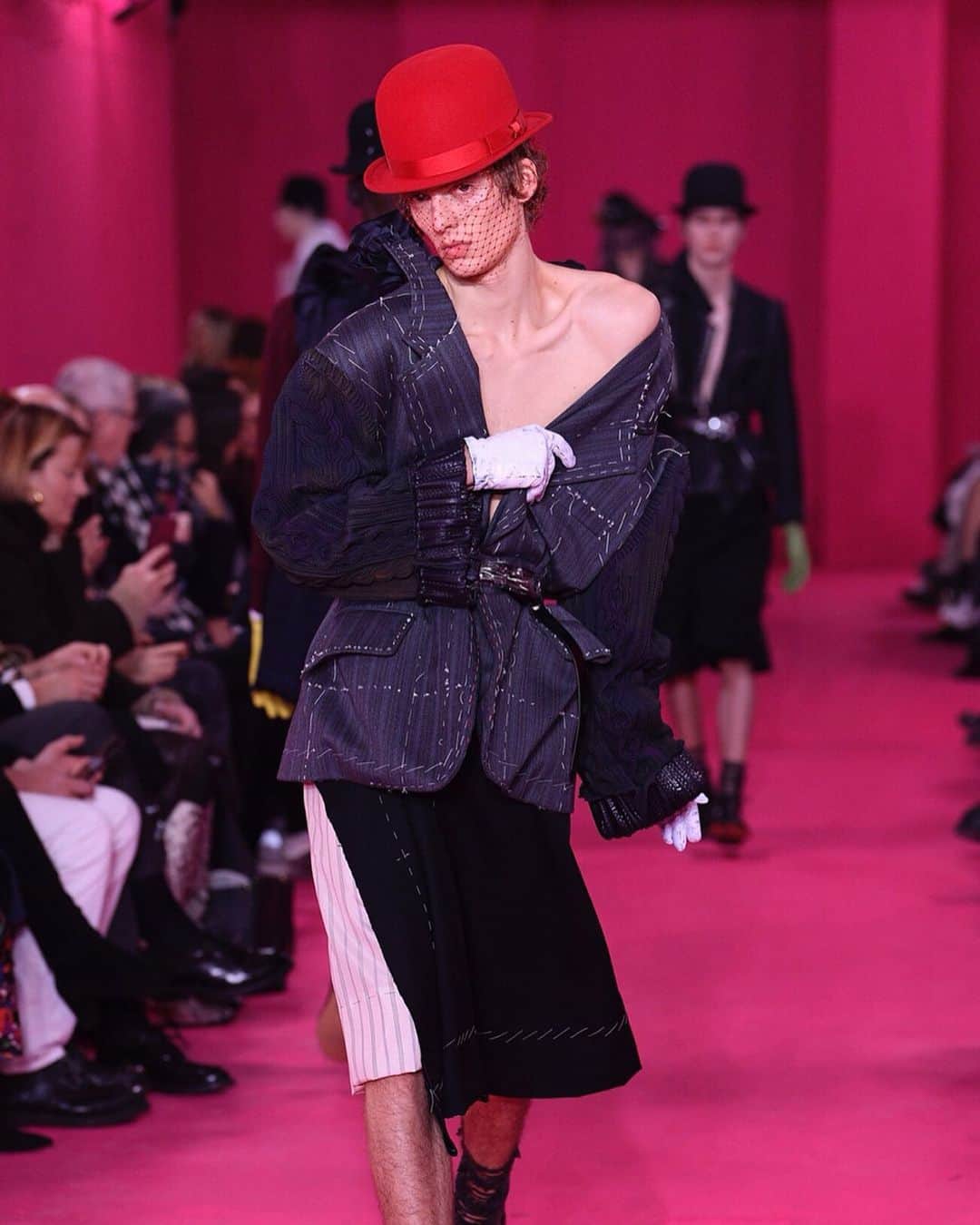 のインスタグラム：「クチュール取材：「メゾン マルジェラ（MAISON MARGIELA）ではオートクチュールを“アーティザナル”と呼び、メゾンの “原液”と位置付けて実験的なアプローチを行います。デザイナーの視点を濁りなく注ぐ、そのことがブランドを強くし、プレタポルテの“売れる”商品につなげています。だから服だけではなく、会場もモデルも一貫性がありおもしろい。﻿ ﻿ 今季のキーワードは“ブルジョワ・ジェスチャー”と“ワーク・イン・プログレス”。正直、前者は難解ですが、後者はわかりやすく、会場演出にも反映されています。動画は独特なウォーキングで話題になっているモデルのレオン・デイム（Leon Dame）。今季はいつもよりエレガントです。﻿ ﻿ ショーが終わり会場の外に出ると路面にも“タビ（TABI)”と「リーボック（REEBOK）」のコラボシューズのピンクの足跡が続いています。たどっていくと近くの「ドーバー ストリート パフューム マーケット（DOVER STREET PAFUME MARKET）」に到着。マルジェラの香水「ミューティニー（MUTINY）」のイベントが開かれていました。と、いった足取りを動画に収めました。よろしければ臨場感をお楽しみください。﻿ ﻿ コレクションの全ルックは @wwd_jp のプロフィールのリンクから﻿ ﻿ 1枚目、PHOTO : GIOVANNI GIANNONI / WWD (c) FAIRCHILD PUBLISHING, LLC﻿ ﻿ #メゾンマルジェラ #MAISONMARGIELA #マルジェラ#MARGIELA #johngalliano #coutureweek #leondame #pariscoutureweek」