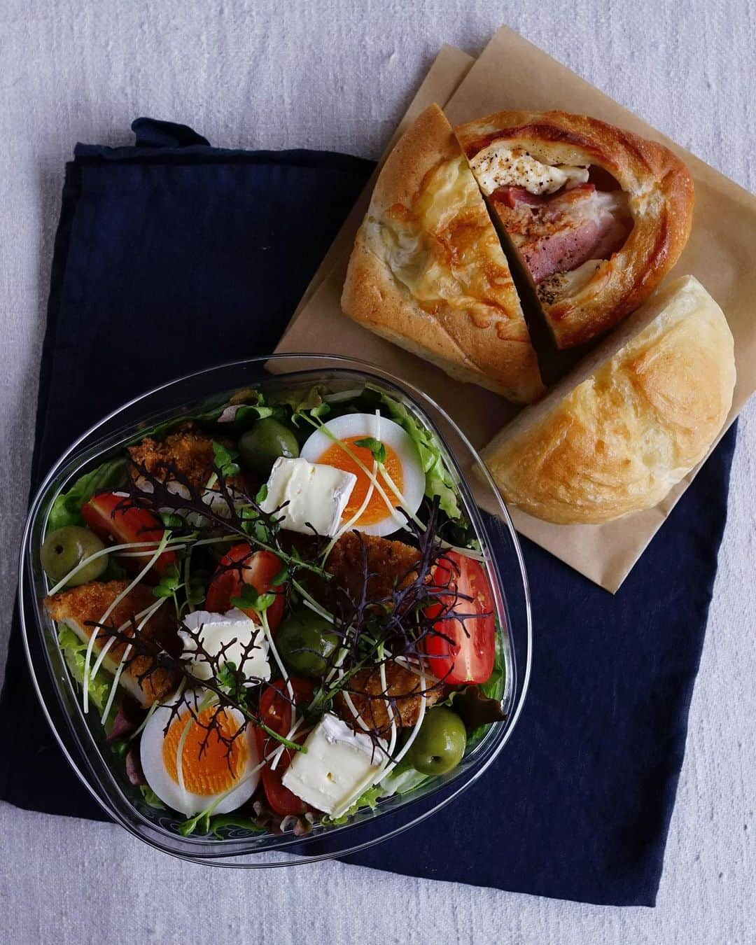 Ryoko Yunokiのインスタグラム：「+ + + Bread and salad bento/パンとサラダのお弁当 . *some bread *green salad, topped with fried chicken, brie cheese, hard-boiled egg, baby tomatoes and green olives, seasoned with salt/pepper and drizzled olive oil . *パン *グリーンサラダ。チキンナゲット、ブリーチーズ、ゆで卵、プチトマト、グリーンオリーブ。味付けは塩胡椒とオリーブオイル。 + + + #bento #お弁当 #丸の内弁当 #f52grams」