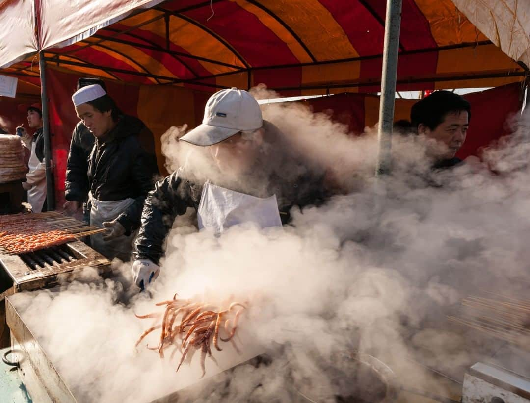 Michael Yamashitaさんのインスタグラム写真 - (Michael YamashitaInstagram)「Steamy Spring Festival: A food vendor grills squid during a temple fair in Lianhuachi Park, Beijing. The celebration is for the Lunar New Year. Due to the coronavirus outbreak, the city has unfortunately canceled major public events including Lunar New Year temple fairs this year.  #beijing #beijingopera #springfestival #chinesenewyear」2月2日 6時01分 - yamashitaphoto