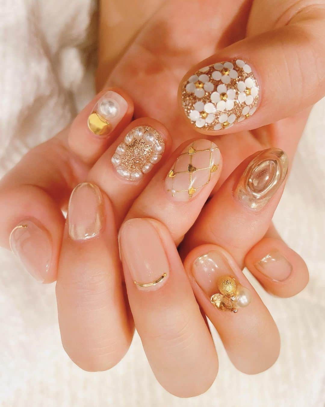 カナさんのインスタグラム写真 - (カナInstagram)「Valentine nails🥂🤍 ． ネイルが可愛いとウキウキするよね🏹👼🏻 ． バレンタインぽく ラブリーなデザインにしたかったから 色はやり過ぎぬようskin color ✖︎ goldにしました🤲🏻 ． 右手はかすみさんとお揃いで ベースは手がキレイに見える チュルっとした透明感のあるヌーディーピンクに とてもキメの細かいラメが入っているよ ゴールドミラーの囲みのぼかしがとても綺麗。。💭 @ksm23_nail_jg ． 左手はずっとやりたかった お花やハートをいっぱい🌼💕 ． 🏠　@juicy_gold.ebisu ． ． #Valentine #valentinenails #juicygold #ebisu #cyberjapan」2月4日 19時01分 - _kana627_