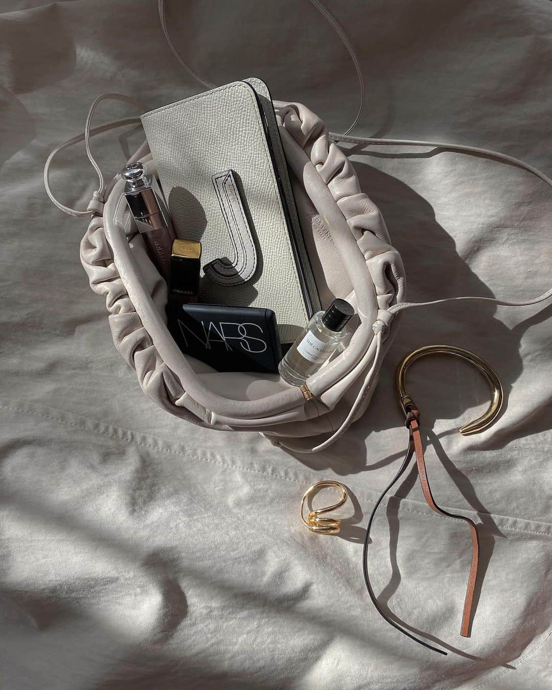 JUNNAのインスタグラム：「ミニマルで映画館へ... ・ ・ bag/ #BOTTEGAVENETA (the pouch mist) smart phone case/ @bonaventura.official  cheek color/ @narsissist (NARS BRUSH 4078) lip gloss/ @diormakeup (MAX MAXIMIZER) lip color/ @chanel.beauty perfume/ #diormakeup (cashmere) bangle/ @loewe ring/ #charlottechesnais ・ ・ #ミニバッグ #ミニマル #バッグの中身 #nars #narscosmetics  #dior💄 #charlottechesnaisjewelry #BOTTEGAVENETA#bottegavenetabag #bonaventura#ボナベンチュラ  #LOEWE #ロエベ #ボッテガヴェネタ #ボッテガ」