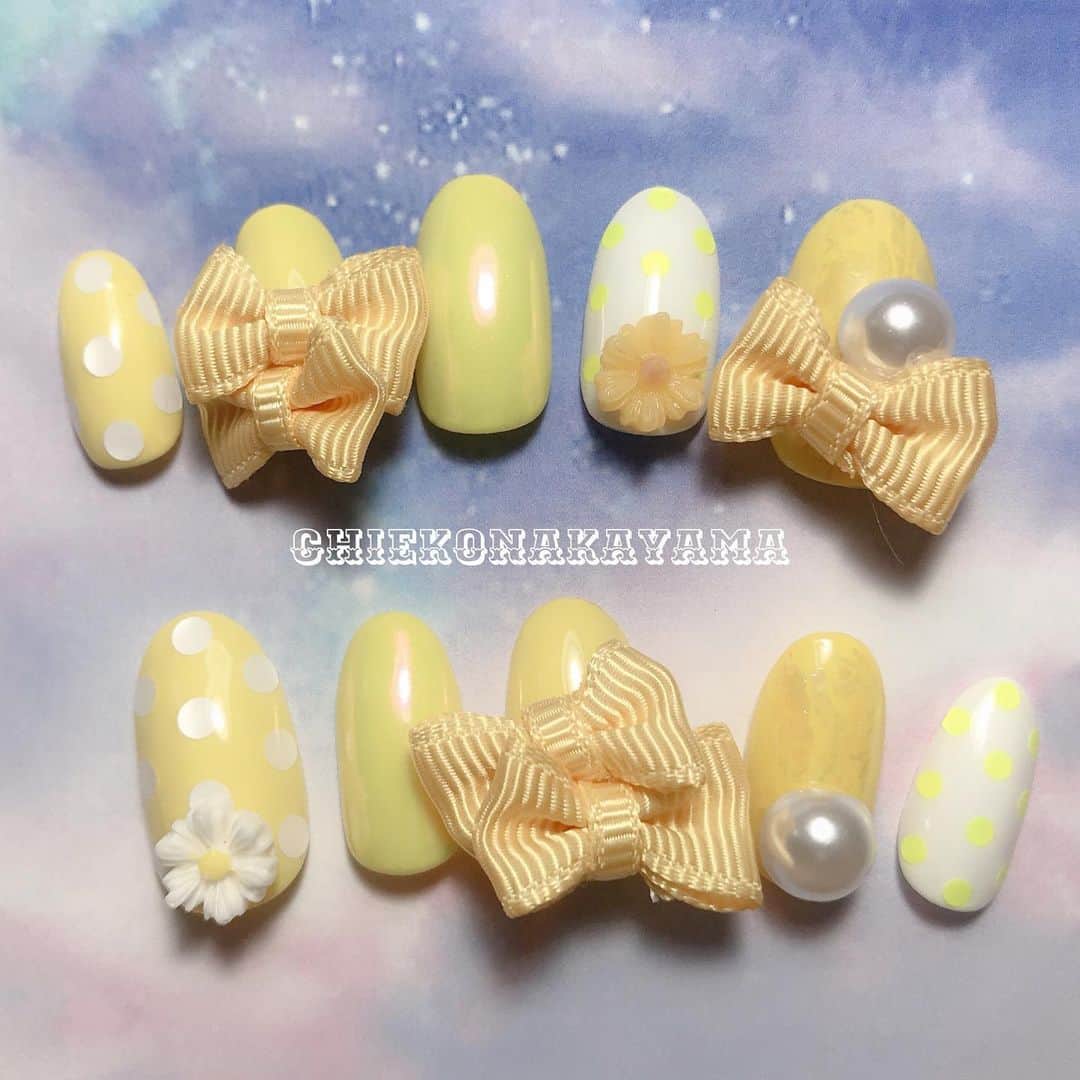 なかやまちえこのインスタグラム：「ポルカドットとメローイエロー @pregelofficial 862 PremDoll B40 PREGEL MUSE M021 MagicPowderとPREXYオーロラホイル✨ @prexyofficial お花パーツ パールは @allthatnail_jp  ホロはどこのか不明、リボンは手芸屋 #nail #nails #nailart #ネイル #美甲 #ネイルアート  #clou #nagel #ongle #ongles #unghia #japanesenailart #manucure #네일 #젤네일 #네일아트 #네일리스트 #メローイエロー #ポルカドット #イエローネイル #yellownails #polkadots @nailvenus_magazine」