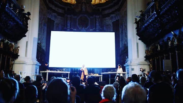 渋谷慶一郎のインスタグラム：「去年、アルス・エレクトロニカで初演した『Heavy Requiem』のトレーラーを作りました。 Heavy Requiem (2019) Concept,Composition,Electronics by Keiichiro Shibuya Buddhist Chant Shomyo by Eizen Fujiwara Visualization by Justine Emard Premier at St.Florian Monastery, Basilika, Austria  Ars Electronica 2019, “AI x Music”  We created a trailer for a new project "Heavy Requiem" that premiered at Ars Electronica last year. Heavy Requiem is a new collaboration that combines a Buddhist chant called Shomyo which has over 1200 years history recited by Eizen Fujiwara, a buddhist monk / musician of Nanzanryu Shyomyo, and electronic music by Keiichiro Shibuya.Unlike western serene requiems, it explores the possibility of festive and sensational one with rhythm, bass and beats created by electronic sounds. The base music that Shibuya composed only with computer-generated electronic sounds consists of six songs that add "consciousness" to the five elements in nature called "earth, fire, water, wood / air, space". Eizen Fujiwara selects and recites six songs of traditional Shomyo according to the image of the six elements. The Shomyo recited by Eizen Fujiwara is transformed by real-time effect generated by Shibuya's computer, as a result, the boundaries of electronic sounds / noise / voice disappears accordingly. At the same time, the electronic sound and the voice of Shomyo independently exist each other without a musical theory like a dichotomy between chords and melody. While aiming for a new model of harmony and equilibrium where there is no relationship between domination and subordination, Shomyo recites world peace at the end of the performance. Video is created and operated by Justine Emard, who is a French video artist and has been collaborating with Shibuya in recent years. She took 3D scan of buildings, Buddha statues, Buddhist tools and nature in Koya-san, and she utilize the visulas with real-time effect according to each song. We made a successful stage as a premiere in the world famous media art festival called Ars Electronica in Austria, and further performances around the world are planned in the near future.」