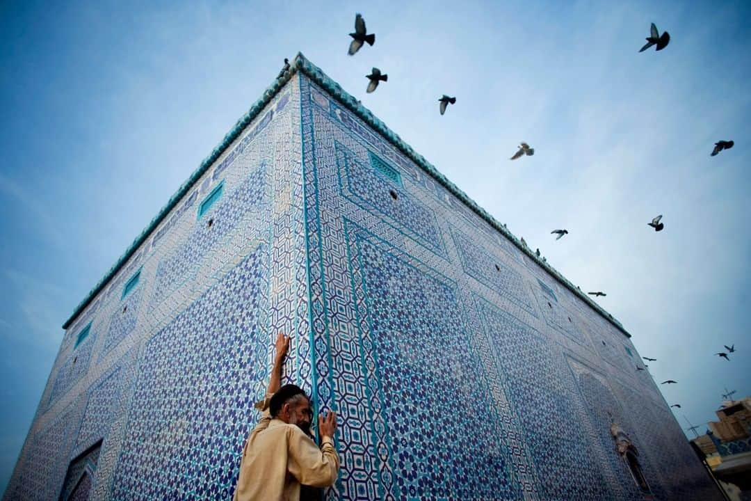 National Geographic Travelさんのインスタグラム写真 - (National Geographic TravelInstagram)「Photo by Aaron Huey @argonautphoto | A Sufi pilgrim embraces the blue-tiled shrine of Shah Yusuf Gardezi in Multan, Pakistan. Built around 1150, this is one of the earliest tiled structures still standing in Asia. Multan is called the City of Saints because of its large concentration of Sufi shrines. Sufism is a mystic practice of Islam, with a focus on gaining knowledge via a direct experience of God, often accompanied by dancing, spinning, singing, and sometimes ecstatic trance.  Follow @argonautphoto for more in an ongoing series on the Sufis.」2月12日 14時10分 - natgeotravel