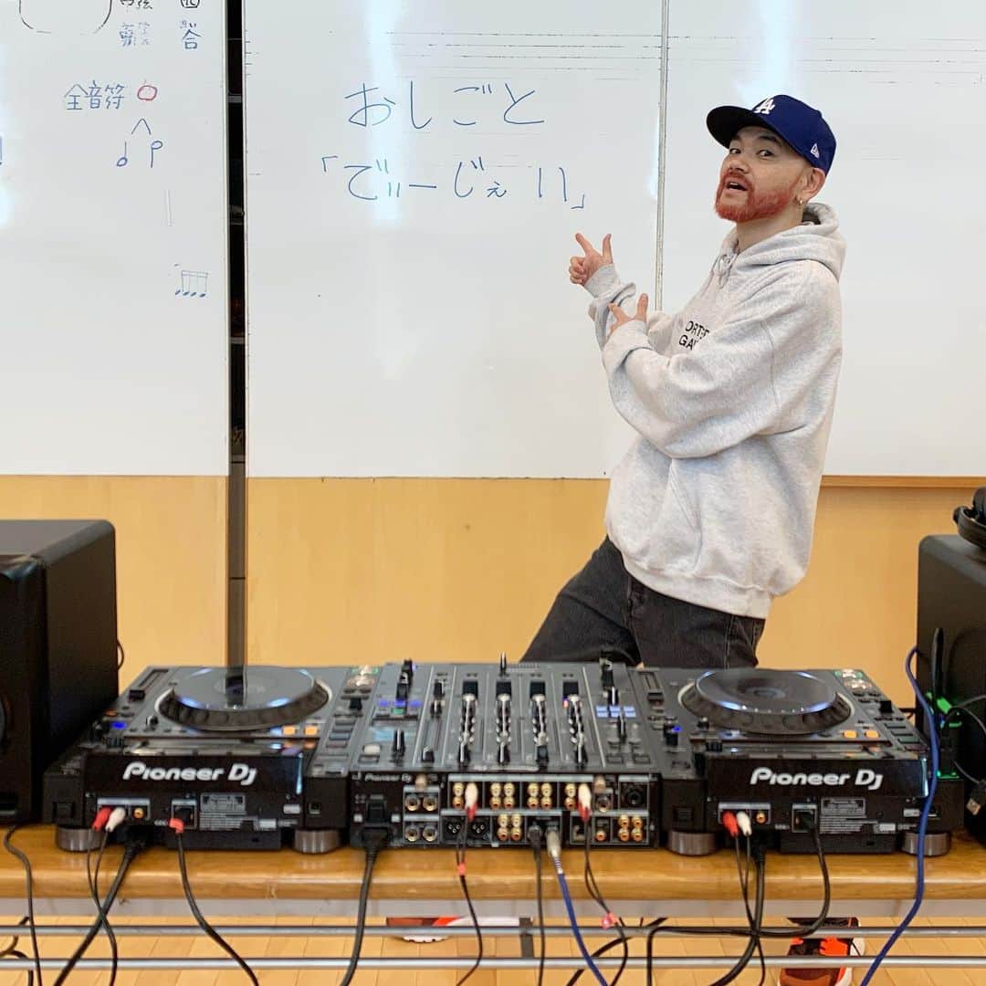 DJ DARUMAのインスタグラム：「👨🏻‍🏫先日#PioneerDJ さんご協力の元 小学校で1年生の生徒達に"おしごと"の授業を してきました。🏫🧒🏻👦🏻🎓 僕のおしごとは勿論"でぃーじぇい" まず皆(子供達)が今"すきだな"とか"たのしい"と 思うことの中に"おしごとのたね"があるよという 話をしました。(写真左側の全音符等は音楽室を お借りした為僕の授業内容では無いです)  僕自身、幼稚園の時にパンダちゃんのレコード プレイヤーを買って貰って”ドリフの早口言葉” と”およげたいやきくん”の再生スピードを 変えたり止めたり、音をコントロールする事が とても楽しかったという原体験から"DJ"という 職業に就いた可能性があるので、子供達にも 難しい事は言わずスクラッチやエフェクト, ピッチコントロールで音に”触る”感覚を 楽しんでもらいました。 結果、終始笑い声が響き渡る最高の授業に。 (やはり歌声や音が単純に"変"になる事に反応する)  最後は子供達皆が知っている大流行歌と テクノを"その場"でミックスして聴かせると 自分達が今触った機械でそんな事が 出来るのかとビックリした様子。  そして次の日全員から感想を頂きました。 "おとのなかにはいれたきがした"って凄い感性💯」