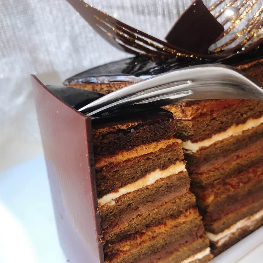 里井真由美さんのインスタグラム写真 - (里井真由美Instagram)「高さ8.5cm！チョコ14層❗️漆黒のチョコレートが織りなす「スーパーオペラ」〜‼️ ・ ・ この迫力ケーキはホテルニューオータニ東京ならでは❤︎ @hotelnewotanitokyo ・ ・ 華やかなデコレーションと14層構造は、厚みや食材が違い、2種類のガナッシュに、2種類のクリーム！  特筆はカラメルバタークリームが味の決め手なんです、コクがあっておいしい🥰♥️ ・ ・ エスプレッソが染みた7層のビスキュイで挟みこまれてます。 14層の中にはアクセントにカラメリゼしたアーモンドが隠れていて食感も良いです❤︎ ・ ・ 自分ご褒美に、ギフトに、パーティーに❤︎ おいしゅうございます❤︎❤︎🍫🍫🍫 ・ ・ #チョコレート#オペラ#ホテルニューオータニ#ホテルニューオータニ東京  #里井真由美 #さといいね#栗スイーツ#デパ地下#ホテルスイーツ#デパ地下スイーツ#ホテル#ありが糖運動#まゆログ#フードジャーナリスト里井真由美」2月16日 11時34分 - mayumi.satoi