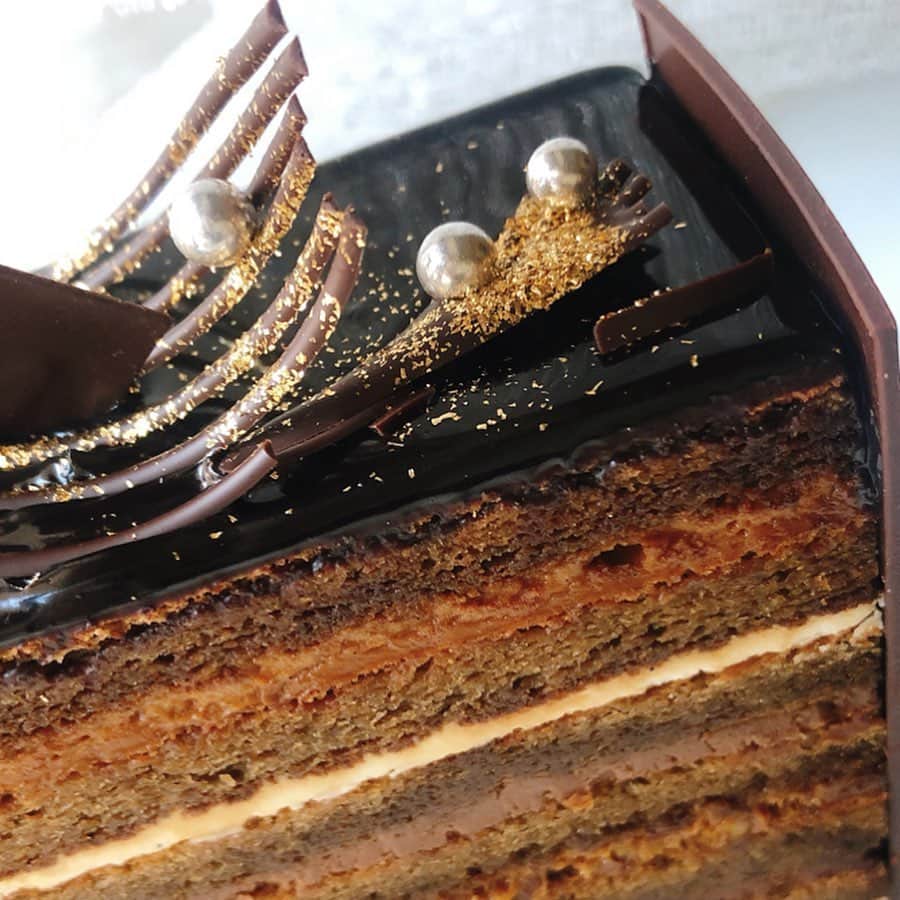 里井真由美さんのインスタグラム写真 - (里井真由美Instagram)「高さ8.5cm！チョコ14層❗️漆黒のチョコレートが織りなす「スーパーオペラ」〜‼️ ・ ・ この迫力ケーキはホテルニューオータニ東京ならでは❤︎ @hotelnewotanitokyo ・ ・ 華やかなデコレーションと14層構造は、厚みや食材が違い、2種類のガナッシュに、2種類のクリーム！  特筆はカラメルバタークリームが味の決め手なんです、コクがあっておいしい🥰♥️ ・ ・ エスプレッソが染みた7層のビスキュイで挟みこまれてます。 14層の中にはアクセントにカラメリゼしたアーモンドが隠れていて食感も良いです❤︎ ・ ・ 自分ご褒美に、ギフトに、パーティーに❤︎ おいしゅうございます❤︎❤︎🍫🍫🍫 ・ ・ #チョコレート#オペラ#ホテルニューオータニ#ホテルニューオータニ東京  #里井真由美 #さといいね#栗スイーツ#デパ地下#ホテルスイーツ#デパ地下スイーツ#ホテル#ありが糖運動#まゆログ#フードジャーナリスト里井真由美」2月16日 11時34分 - mayumi.satoi