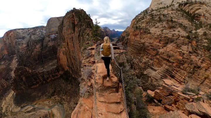 Travis Burkeのインスタグラム：「1,000 ft (300m) drop on either side with a tiny trail cut into solid rock, all leading you skyward to Angels Landing in Zion National Park.  @gypsealaysea taking in the views during our ascent.  Have you done this hike or is it on your bucket list?  #zion #angelslanding #utah #gopro」