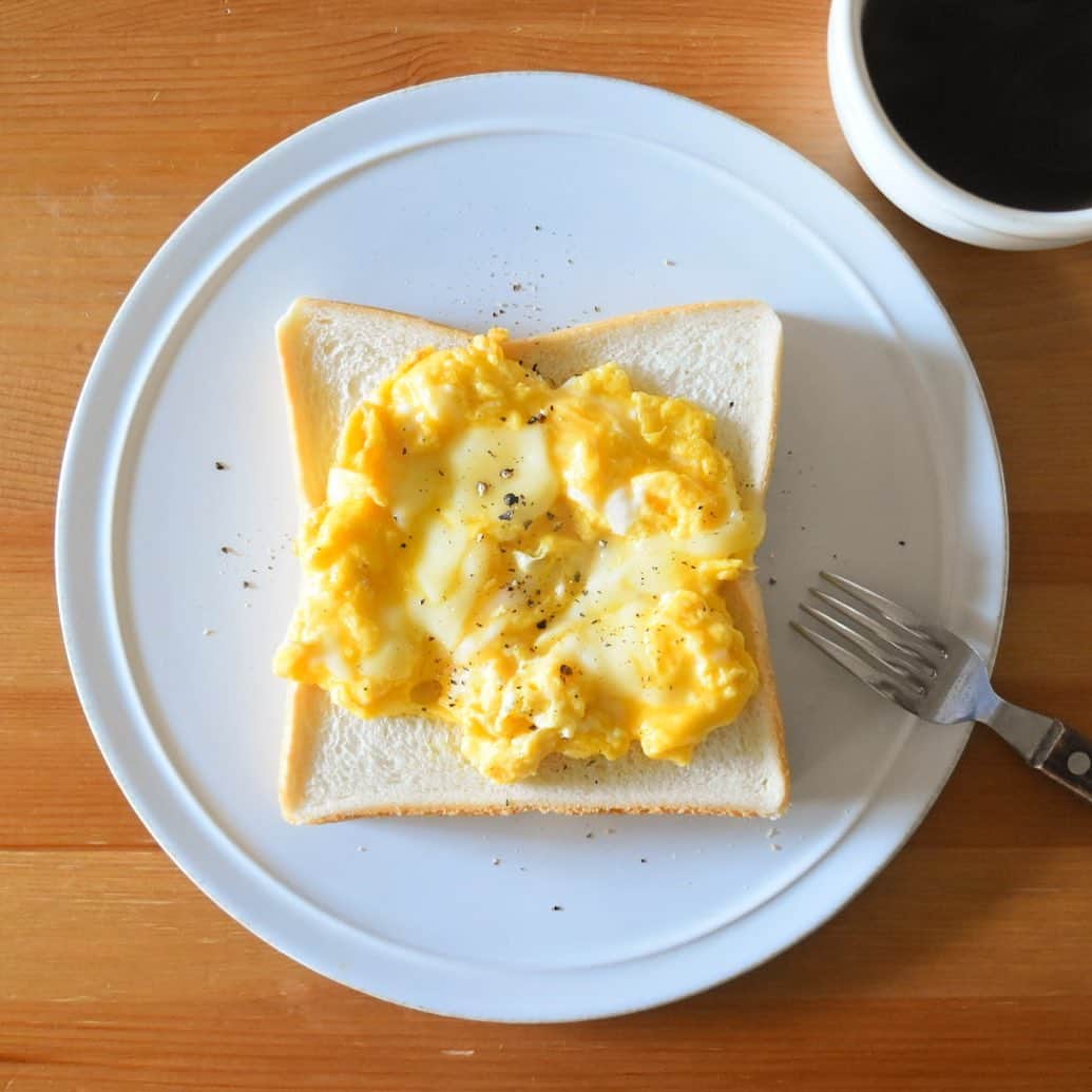 山崎佳のインスタグラム：「Today’s breakfast. コロナウイルス対策で、私が働いている会社もリモートワーク推奨。月、火は自宅で仕事して、今日はミーティングなどあるので出社です。 家で仕事だと、通勤時間分の余裕があるし、お昼休憩がてら夕飯も作ったりできるんだけど、会社に行く日は保育園送っていくまでに夕飯作りやお風呂掃除なども済ませなきゃいけないから、やっぱりバタバタするなぁ。 なので今朝は、めっちゃ雑なチーズ入りスクランブルエッグのせ。とろけるチーズ手で適当にちぎって卵に混ぜて、フライパンに入れたらすぐ火をきっちゃう。余熱で好きなくらいのとろりになったらパンにのせて終わり。超早い。」