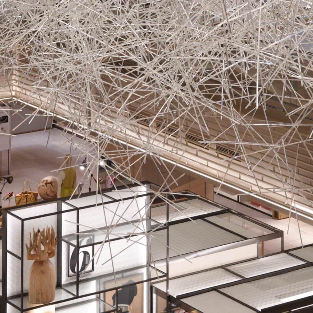 林信行のインスタグラム：「Prismatic Cloud [ #GinzaSix version ] by #TokujinYoshioka  #吉岡徳仁  巨大にして繊細。吉岡徳仁さんの作品が3周年のGINZA SIXの吹き抜けに(10月下旬までの予定)。 雲のように淡く反対側のお店が透けて見えるのに、じっくり雲そのものに目の焦点を合わせると実は凄い密度で、しかも硬質感が浮かび上がってくる。それもそのはずで雲の正体は約1万本のプリズムロッド。  プリズムとはいってもプリズムを感じさせる虹色の反射はなく、ほとんどのロッドは白い光を反射しているのだけれど、歩きながらよく見ていると稀に小さな虹色の反射を見つけることができて、それもまた楽しい。  これまでもGINZA SIXの吹き抜けアート作品は楽しみで、好きな作品多かったけれど、最初の草間さん作品から個性と主張が強い作品多くてお店はお店、アートはアートと分離してる感じがあった。 Prismatic Cloud の静かな主張は空間そのものを引き立ててくれるし商業施設のインスタレーションとしてもかなり良いのではないか、と思った。 とにかく美しく、本物の雲のようにじっと眺めていたくなる。 銀座に行ったらお見逃しなく！」