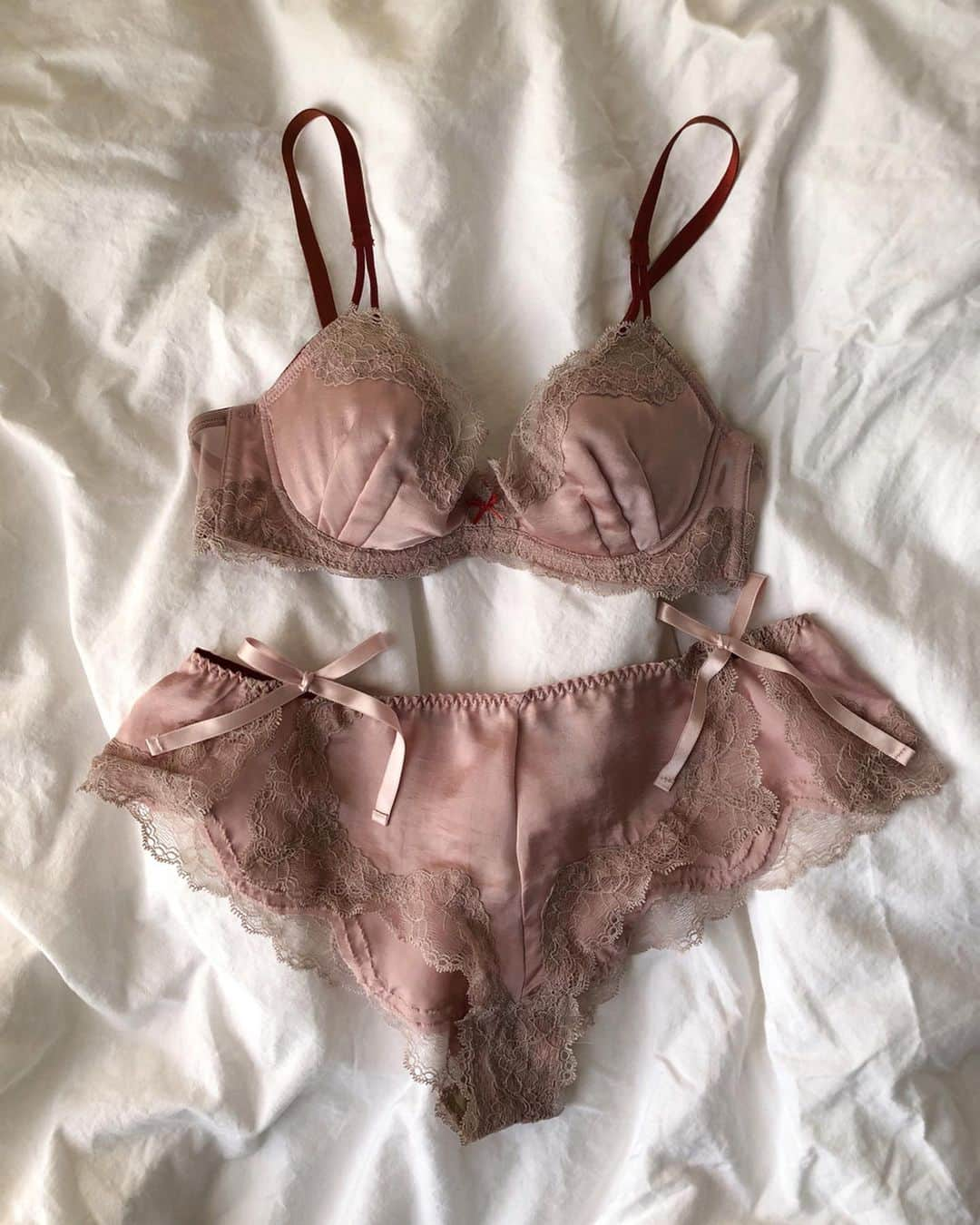 ベイカー恵利沙さんのインスタグラム写真 - (ベイカー恵利沙Instagram)「@chut_intimates x ElisaBaker ピンクベージュは、私が一番使うランジェリーのカラー。 服に響かず、肌にしっとりとした喜びを与えてくれる ピンクでもない、ベージュでもない、 ピンクベージュ。 つるっととしたサテンに、 同系色のくすみピンクのレース、 熱っぽさをプラスする深い赤のストラップ 付けた瞬間、体にぽっと馴染んで きっと私たちの味方になってくれる ♡ vintageっぽさにこだわったレースはとにかく華奢で繊細 とろんとしたヴィンテージサテンにとても良く合う ピンクを大人に着られるように 同色のくすみのあるレースを重ねて 深い赤のアクセントを ♡ ショーツは通常のタイプ、Tバック、そしてこの写真のフレアショーツがあります。 まさに映画のワンシーンから出てきたようなフレアショーツ🎀 両サイドがリボンで繋がれていて ヘルシーに色っぽい お部屋でこれにトレーナーなんてとっても可愛いし、 もちろん毎日の着け心地にも最高！ オンライン、全国の店舗で発売中💖」2月28日 21時39分 - bakerelisa