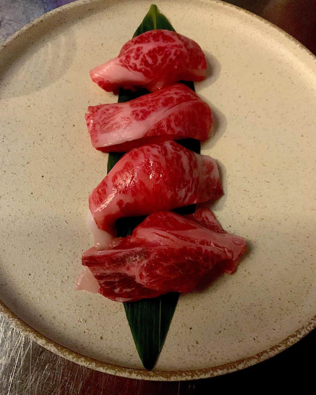 のインスタグラム：「昨夜は会員制の秘密のお店で、磯田さんの松坂牛A5 12番。 という知る人ぞ知る幻のお肉に酔いしれてきました🍷🥩 A5は知ってるけど12番って❓という方に簡単解説すると、  これはＢＭＳ(ビーフマーブリングスタンダート)という霜降り具合を表すもので、 １～12までのランクがあります。  A5 12番というのは牛肉の中で最高ランクを意味するわけですが、更に‼️ 松坂牛に詳しい方なら、磯田さんの…と聞いただけでも「おぉ…‼️」となる、伝説の生産者なのだとか。 松坂牛の中でも特別な育て方をするため、 「住にし方の大石牛」という商標登録もされていらっしゃるそうです。  年齢的にも、脂の入り過ぎたお肉は一口でもう十分💦と、普通の牛ならなるのですが、良いお肉って脂がサラリとしているというか、全くもたれる感じがないんですよね。  それどころか目をつぶってこのお刺身食べたら、トロを食べてるのかお肉を食べてるのか、はたまた今まで食べたことのない何かを食べてるのか、わからないかもしれない。  というくらい、衝撃的な美味しさでした💖」