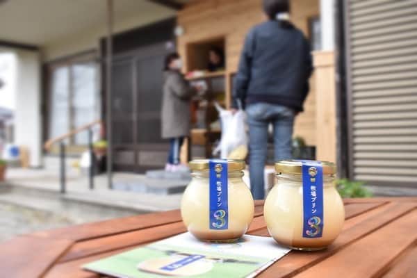 さが農村のインスタグラム：「. 街のかわいいプリン屋さん?!! . と思ったら、【大富牧場】 …牧場？(*「・ω・)？ . ここは、佐賀県みやき町で乳牛と肉牛を飼育されている大富牧場さんが自身のオリジナル商品「牧場プリン３（さん）」を販売するお店なのですd((*´▽`*) . 「さが農村」でも何度か紹介させていただいた「牧場プリン3」。プリンの販売を始めてからメディア等に取り 上げられ、直接牧場に買いにこられることも多くなってきたので防疫のためにもこの販売所をつくられたのだとか。 . お店の外には座れるスペースがあったり、 入り口横をあけると座布団が用意されていたりして、「“農業女子”のよりどころになればいいなと思って」と大富さん(人´v`)* まさに、『生産者と消費者が直につながれる場所』そんな場所を作りたかったのだそうです。 . 外には近隣の農場業女子が持ち寄った新鮮な農産物も販売されています。（この日はいちご、ほうれんそう、トマト、ミニトマトが☆） . 「生乳」「卵」「きびさとう」３つの材（！！）のみで作られたおいしいプリンはもちろん、 とーっても明るくて気さくな大富さん。 お客さんにリピーターが多いというのも納得です♪ . . ↓営業日時をご確認の上おでかけください。 . ＜大富牧場フライングカウ＞ ●住所：みやき町簑原708（ナフコ中原店南側） ●問い合わせ先：090-4812-1215 ●販売日時 毎週金曜 11:00～16:00 第3土曜  9:00～12:00 . . ■さが農村ひろばTOPページ https://saga-nouson.jp/ . . #さが農村#佐賀産#さが#サガ#佐賀#saga#牧場プリン3#大富牧場」