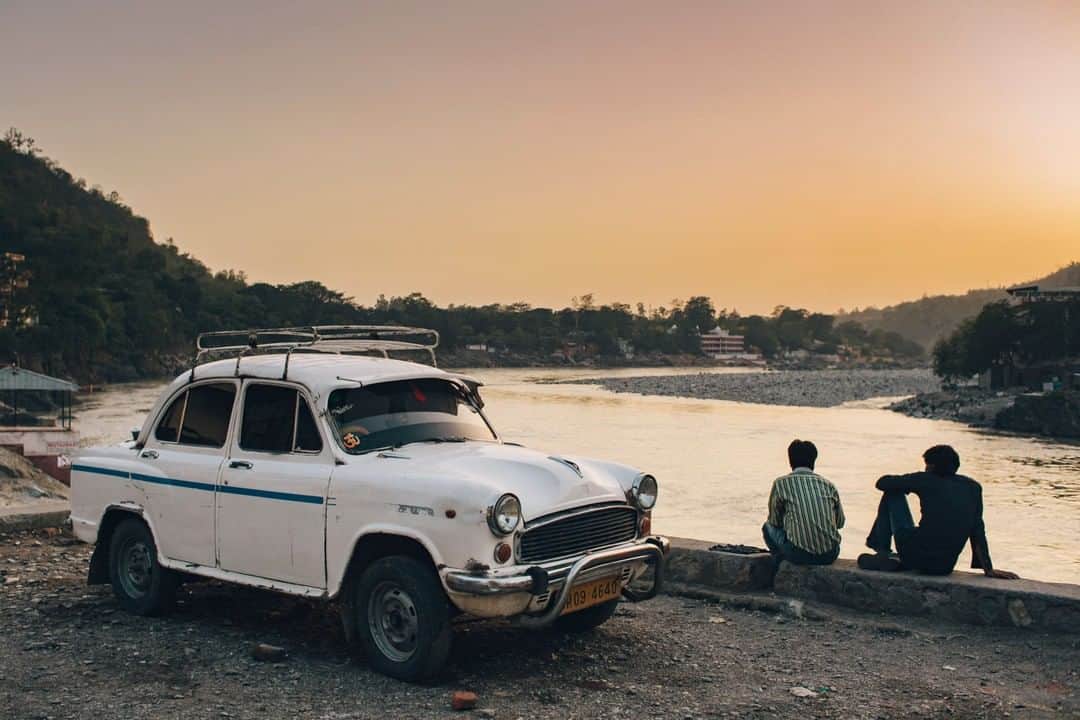 National Geographic Travelさんのインスタグラム写真 - (National Geographic TravelInstagram)「Photo by @joshuacogan | Two men overlook the Ganges River near its headwaters in Rishikesh, India, with a classic Ambassador car beside them.」3月21日 17時08分 - natgeotravel