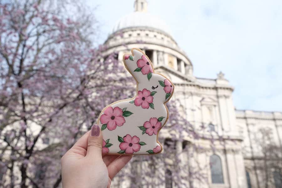 KUNIKAのインスタグラム：「Easter rabbit painted cookie with lovely cherry blossoms at St. Paul's Cathedral🐇🌸﻿ ﻿ 少しだけ咲き始めた桜とともに🌸﻿ 日本のより少しピンク味が強くて、大ぶりな花びらなロンドンの桜。 セントポール大聖堂の周りはこれからの季節によって桜、チューリップ、薔薇、とお花が綺麗に咲いてるので行かれた際にはぜひお花と共にお写真を🌷﻿ ﻿ ﻿ ﻿ #artofkunika #sugarcookies #decoratedcookies #cookieart #decoratedsugarcookies #royalicing #royalicingcookies #cookiedecorating #customcookies #cookiesofinstagram #cookiedesign #cookieartist #instacookie #london #easter #eastercookies #eastercookies🐰 #easterrabbit #paintingcookies #アイシングクッキー #ロンドン」