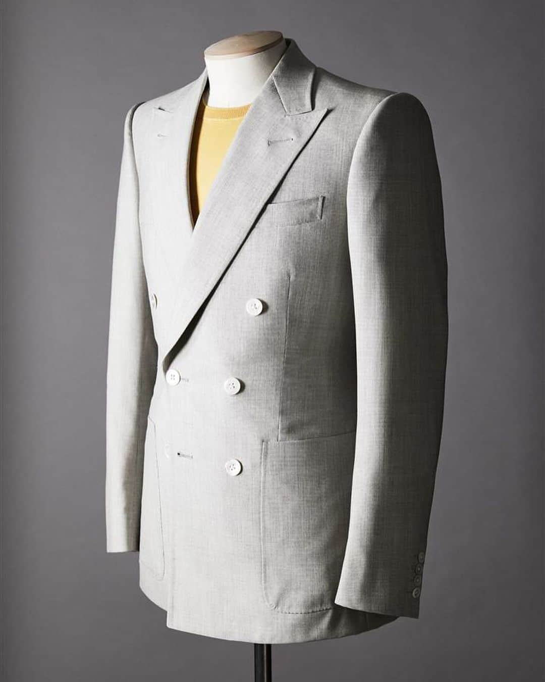 ギーブス&ホークスのインスタグラム：「Bespoke lightweight worsted double-breasted suit  In warm climates, breathable, comfortable tailoring is essential.This pearl grey two-piece suit has a lightweight construction, and is cut from a superfine cloth with an open weave to help it keep the wearer cool in the heat. Patch pockets at the hips and white mother-of-pearl buttons lend the design a relaxed edge.  Speak to a member of the Bespoke team to find out how to get your Bespoke summer suit in time for when the mercury begins to rise.」