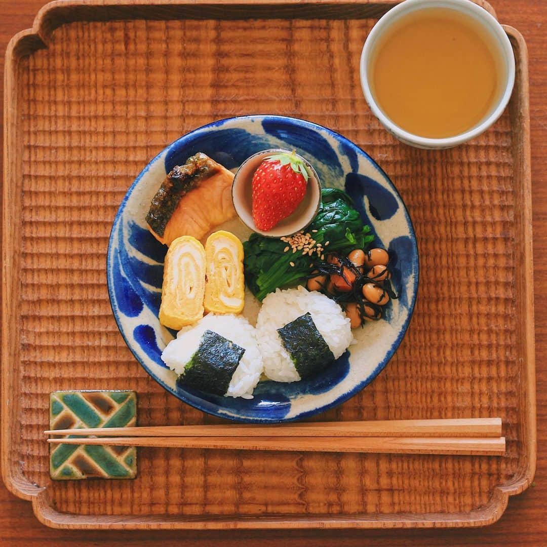 Kaori from Japanese Kitchenさんのインスタグラム写真 - (Kaori from Japanese KitchenInstagram)「在宅勤務中の朝昼ごはん。やちむんを使って沖縄への想いをめぐらす昼休み。 ・ こんばんは。 在宅勤務中の朝昼ごはん。 とにかく準備に時間をかけたくなかったので #パルシステム の冷凍鮭をチンして家にある総菜を盛り 小さく握ったおにぎりを添えて10分で終了。 準備〜食べる〜洗い物まで 1時間以内で収まりました✌🏻 元々インスタにアップするつもりはなく 在宅勤務の気分転換に盛り付けたら いつも以上に綺麗に盛り付けられて せっせと記念撮影(おい、在宅勤務笑) そういう事情で味噌汁は無し。 満腹だと眠くなるし 腹7分目くらいがちょうど良いかな、と 思ってましたが案の定夕方には腹ペコでした笑 楽だし自分自身も目で楽しめたし このスタイルはアリよりのアリ。 ・ iPhone7と比較したらわかるように 器の大きさは5寸くらいと かなり小さなワンプレートです。 やちむんの青は料理をおいしく見せてくれますね。 あー沖縄旅行いきたいな。 安心して旅行へ行けるのはまだ先かな。 海外も国内も旅行の予定が立てられず 妄想ばかりが膨らんで困ってます。 …以上、旅行好きのしょーもない独り言でした。 今日もお疲れ様でした。 ・ 【おしながき】 三角こにぎり 卵焼き ほうれん草のごまポン酢和え ひじきと大豆の煮物 焼き鮭半身 いちご ＊今日は薬膳走り書きはお休みします＊ ・ Hi from Tokyo! Here's late Japanese breakfast:Riceballs,grilled salmon, rolled egg omelette, boiled spinach, simmered hijiki seaweed and strawberry as a dessert. ・ ・ 2020.03.12 Thu ・ ・ #japanesemeal #washoku #breakfast #朝ごはん #おうちごはん #早餐 #아침밥 #薬膳 #うつわ #和食器 #自炊 #やちむん #落合芝地 #ワンプレート #卵焼き #在宅勤務」3月12日 18時29分 - coco_kontasu