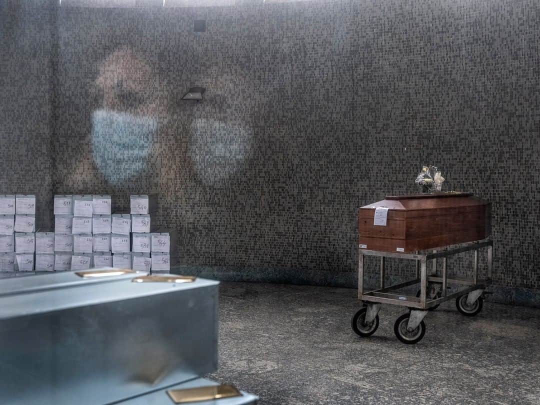 のインスタグラム：「Photo by @gabrielegalimbertiphoto I Italy lockdown, Day 6. In the mortuary of one of the biggest cemeteries in Milan, a woman looks at a coffin sent here from one of the city hospitals. It contains the body of a foreign citizen, and must be sent back to the country of origin. As of March 13, there have been 890 victims of COVID-19 in Lombardy, Italy, which account for about two-thirds of the victims in the country. In Bergamo, a city 60 kilometers (about 35 miles) from Milan, authorities were forced to store coffins in churches after the hospitals and morgues ran out of space. The untold fear is that cemeteries could fill up as well.  #coronavirus #milano #italy #virus #covid19」