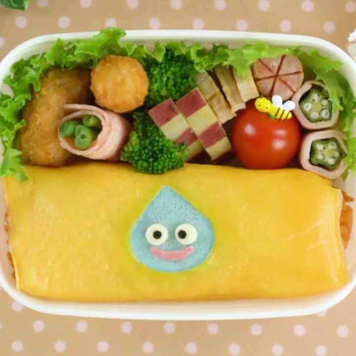 MABRE [マーブル] 笑顔を作るレシピのインスタグラム：「⠀ ドラクエのスライムの水玉オムライス弁当💕⠀ Dragon Quest's Slime Bento🍱⠀ ━━━━━━━━━━━━━━━━━━⠀ 人気ゲーム「ドラゴンクエスト」シリーズのスライムの水玉オムライスです🎶⠀ 楕円形としずく形の型抜きを使ってスライムっぽい輪郭を作ってみました✨⠀ 余裕があれば1体以上作ってにぎやかなオムライスにするのもアリです👍⠀ ⠀ 💡カットや盛り付ける瞬間など⠀ 💡動画を一時停止で見たい人は...🤔⠀ 💡Youtubeで「mabre キャラ弁」と検索してね🧚‍✨⠀ ━━━━━━━━━━━━━━━━━━⠀ 【材料】⠀ ・海苔 1枚⠀ ・スライスチーズ 1枚⠀ ・ビアハム 1枚⠀ ・卵 1個⠀ ・白身 適量⠀ ・デコふり(青) 適量⠀ ・ケチャップライス 適量⠀ ・油 少量⠀ ・マヨネーズ 少量⠀ ⠀ 【作り方】⠀ ① 卵の白身とデコふり(青)を混ぜる⠀ ⠀ ② 海苔で黒目、スライスチーズで白目、ビアハムで口を作る⠀ ⠀ ③ 薄焼き卵を作る準備をする。卵をボウルに入れて混ぜる。茶漉しで濾す⠀ ⠀ ④ 油を薄く敷いたプライパンに(3)を入れて薄焼き卵を作る⠀ ⠀ ⑤ 片面が焼けたら楕円としずくの型抜きでくり抜く⠀ ⠀ ⑥ くり抜いた所に(1)を流し込む。(1)が固まったらひっくり返して裏面も焼く⠀ ⠀ ⑦ 焼けたらラップの上に乗せて、その上にケチャップライスを乗せて巻く⠀ ⠀ ⑧ お弁当箱に詰めて、少量のマヨネーズを使って顔パーツをつけたら完成⠀ ━━━━━━━━━━━━━━━━━━⠀ MABREではキャラ弁を作る皆様からの投稿をお待ちしております😊⠀ ⠀ #マーブルレシピ と付けるだけ👍✨⠀ 投稿してくれた方は⠀ Instagramでの投稿やストーリーだけではなく⠀ Twitter、Facebook、公式webサイトでも紹介させていただきます🧚‍✨」