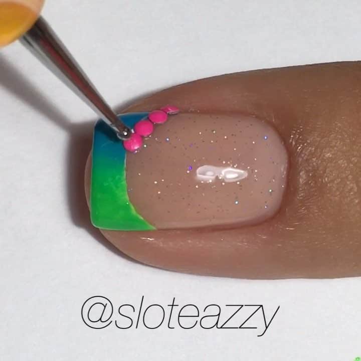 Yasmeenのインスタグラム：「❤️💛💚💙💜 Polishes used: @kiaraskynails Only Natural with @inmnails Northern Lights as the base. Nina Ultra Pro French White, Island Girl Aloha Magic (blue) and @pipedreampolish High Roller (green), all topped with HK Girl Top Coat. Neon studs from @oceannailsupply , adhered with brush on Resin , also from @oceannailsupply . The purple stuff is Liquid Palisade by @kiesque . Stickers are paper reinforcements, latex free make up sponge, both from the 99 cent store. Clean up brush is Kolinsky French brush off eBay. Step 1️⃣ Start with a completely dry base, apply sticker and polish tip white 2️⃣ Remove sticker right away and clean up any mess , apply quick dry topcoat ( I do this to help everything dry completely)  3️⃣ Apply Liquid Palisade as shown, let dry 4️⃣ Paint colors onto sponge, sponge onto nail, repeat as needed 5️⃣ Peel off Liquid Palisade, Clean up , top coat! 6️⃣ Apply resin along smile line  7️⃣ Place studs and you're done! **SONG 🎵 Major Lazer (ft. Nyla & Fuse ODG) - Light It Up [Remix]  #nailsbysloteazzy #sloteazzytutorials」