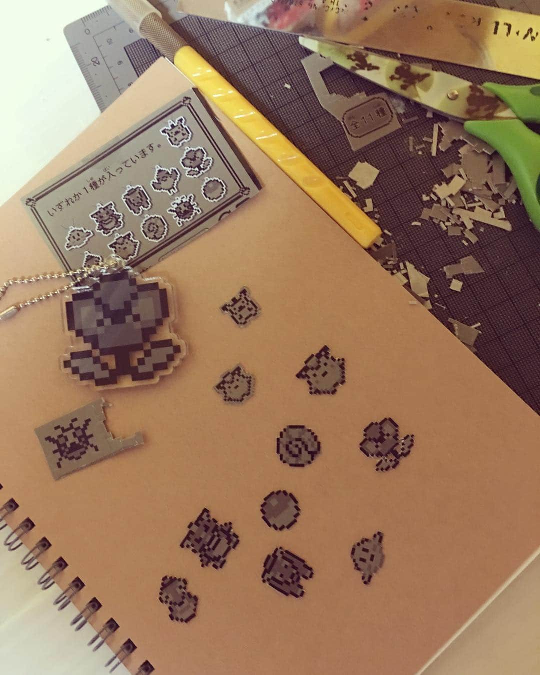 小林真文のインスタグラム：「ポケモンキーホルダーの箱のドット絵をこまこま切り抜き。無印のノートに貼るのでぃす」