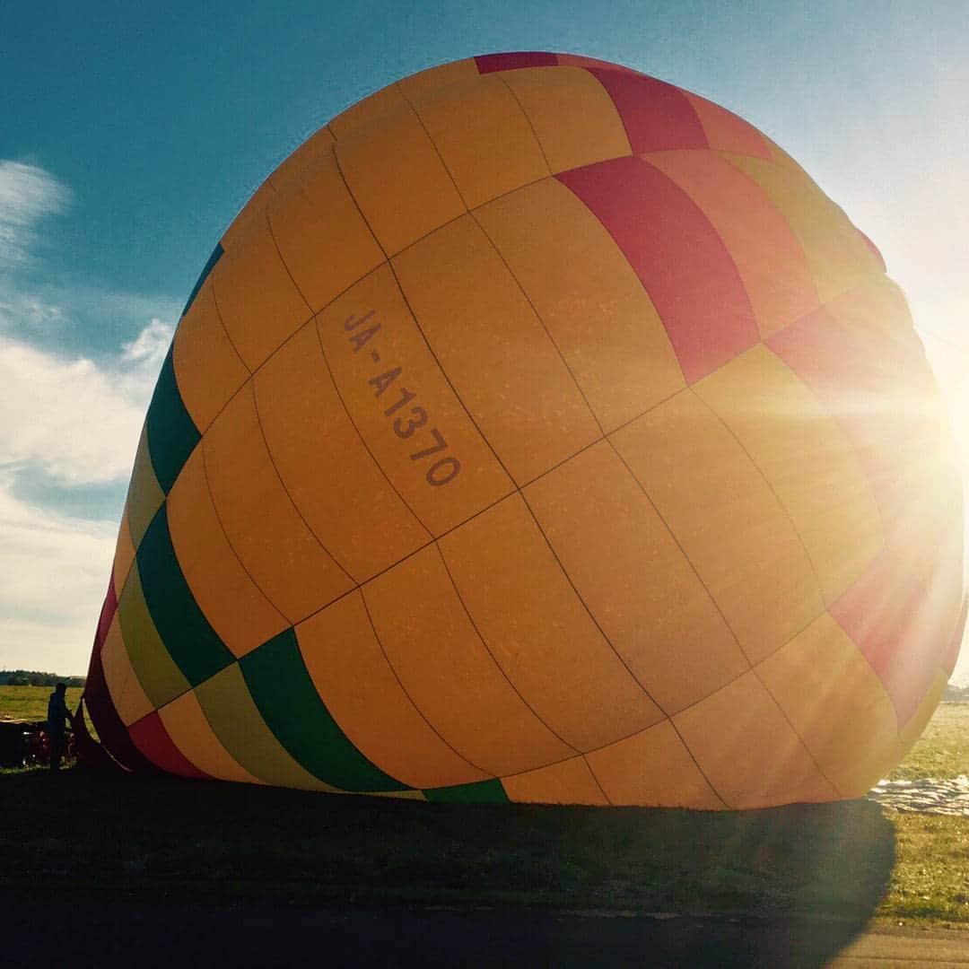 齋藤飛鳥 写真集『潮騒』のインスタグラム：「日の出から出発して大草原に到着。 私たちの目の前に現れたのは、なんと気球でした🌞  #青空 #気球 #風もなく」