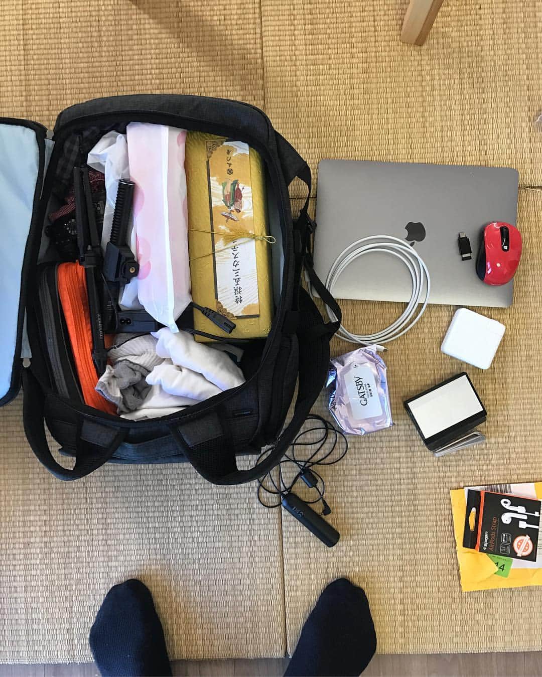 瀬戸弘司のインスタグラム：「レンズつけたGH4、服、ガジェットポーチ、お土産、全部入った。 横に散らばってるものも、オモテ面のポケットに全部入ります。  頼もしいねえ。  #かわるビジネスリュック」