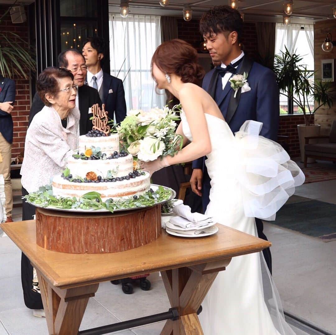磯部奈央さんのインスタグラム写真 - (磯部奈央Instagram)「Wedding cake 🎂. . 結構探したウッドのケーキトッパーと、ブルーベリー×ドライオレンジで大人っぽく仕上げた、好みすぎるウェディングケーキ🎂❤︎. . 普通の流れとは変化球で、. ケーキカットをルーフトップで行いました！！. 晴れてくれてよかった〜🙈. . 今まで美味しいごはんを作ってきてくれた母へ、サンクスバイトも行いました🥄❤︎. . （スワイプして）6枚目の、彼の大切なおじいちゃん&おばあちゃんとの写真もお気に入り✨. ちなみにウェディングドレスもオーダーメイドです❤︎. . . #wedding #weddingdress #weddingparty #結婚式 #結婚 #ウェディングドレス #挙式 #ウェディングケーキ #weddingcake #感動 #こだわり #オーダー #オーダーメイド #うめなおwedding #ケーキトッパー」6月13日 1時22分 - nao_isobe729