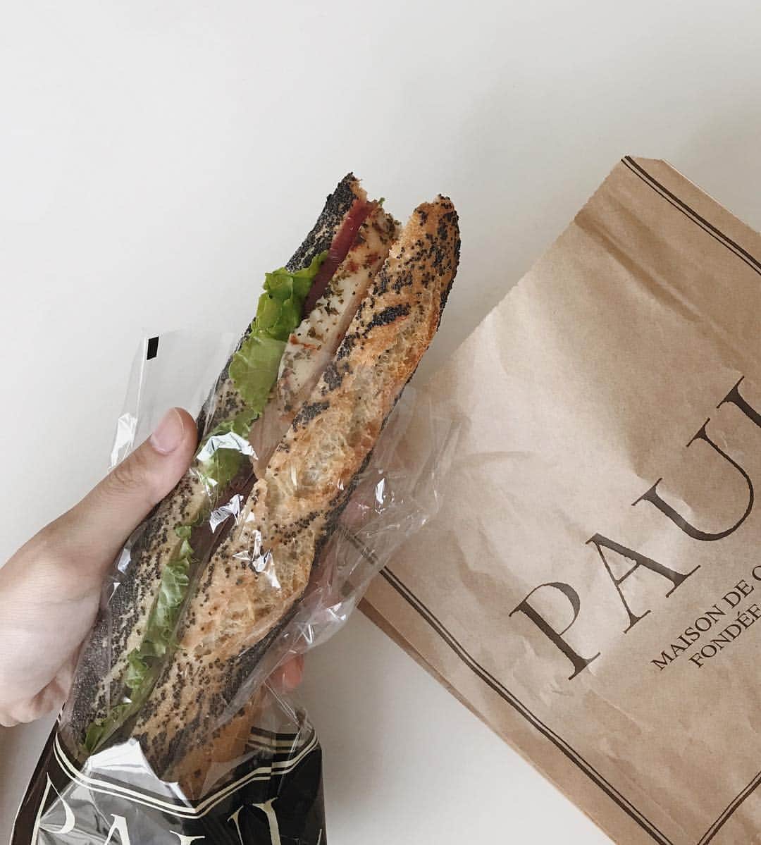 のインスタグラム：「paul🥖 好き パプリカチキンと野菜を、けしの実をまぶしたフランスパンでサンド 美味しすぎる.... 右の袋の中には毎回必ず買う パン・ショコラ 無限に食べたい。」